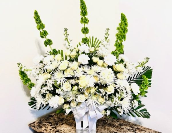 Heartfelt - “Those who go away leave behind a thousand memories”. This is a large calming arrangement in hues of white and cream roses, chrysanthemums, fragrant stocks paired with seasonal foliage to soothe the storms inside.The whites signify the many bright memories of the good times and green for the evergreen love we hold for them because they will never be forgotten. We can create this style with flowers and colors that suit your need .Please give us a call to discuss your options.For same day delivery and Free Delivery Options Text or Call  832-973-1376.  