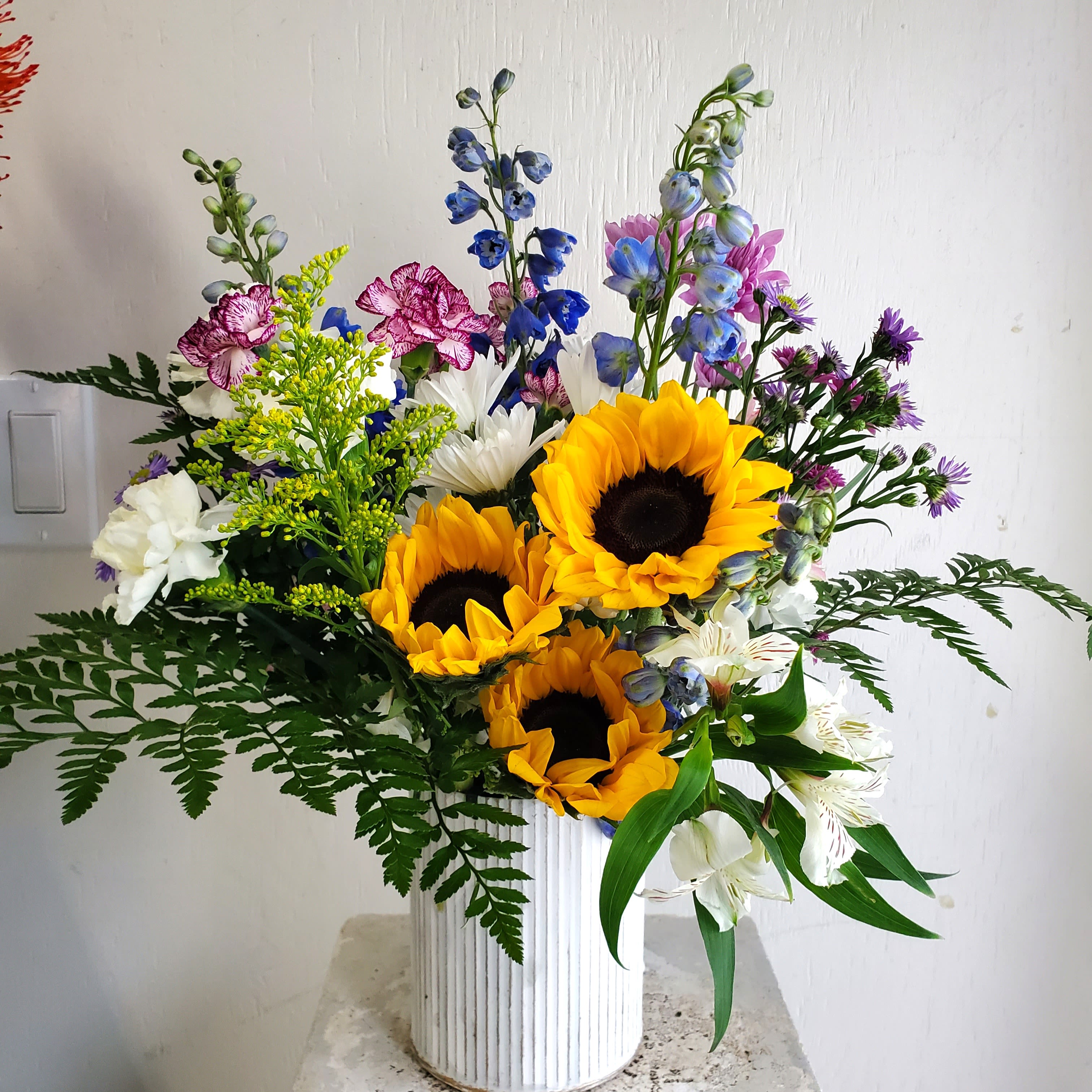 Marching Into Spring - We are a small studio florist in a small town. Every bouquet we create is a one-of-a-kind creation, tailored to the season, availability of flowers, color choice, artistic interpretation, and the current materials available. The photos do not represent the exact flowers that will be delivered. They are intended to provide you with an idea of what we do, how we do it, and the variance that can be expected.The season, availability of flowers, color choice, artistic interpretation, and the current materials available. The photos do not represent the exact flowers that will be delivered. They are intended to provide you with an idea of what we do, how we do it, and the variance that can be expected. 