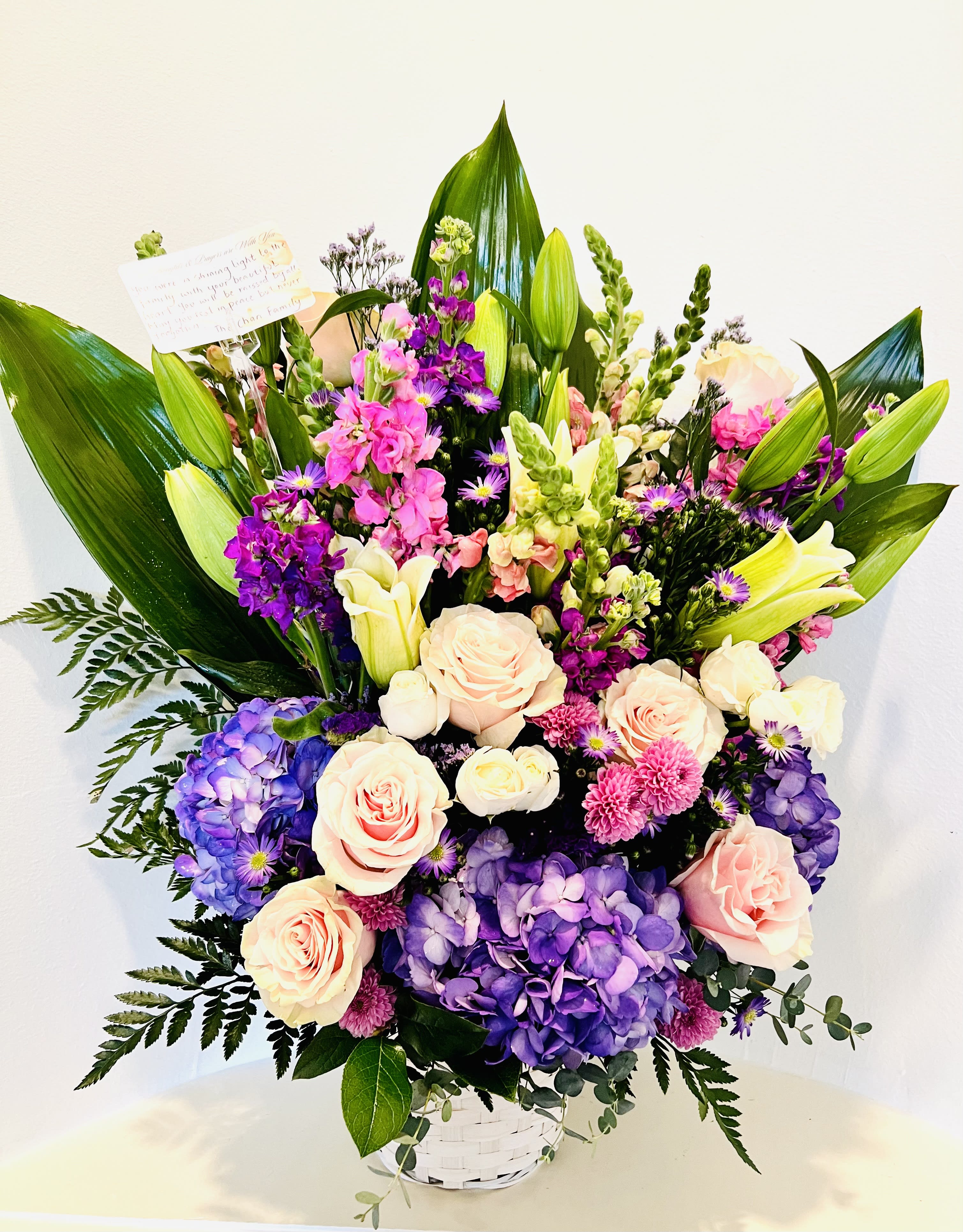 Winnie - Created with purple,mauve and pink blooms , winnie is the one for purple lovers. This gorgeous arrangement has light pink roses,purple,mauve stocks and white lilies tastefully arranged with accent flowers and seasonal greens.For same day delivery and Free Delivery Options Text or Call  832-973-1376.