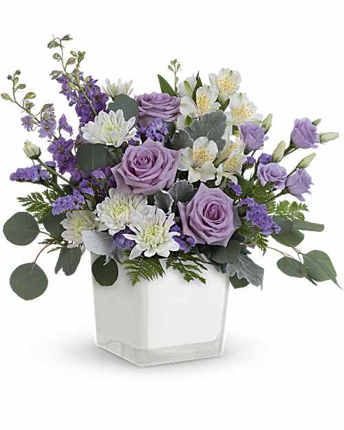  Honey Lavender Blooms Bouquet -  Loveliest lavender! Make any day feel extra special with the soft purple hues of this luxurious rose bouquet, presented in a soft white glass cube. Lavender roses, white alstroemeria, lavender lisianthus, lavender larkspur, white cushion spray chrysanthemums and lavender sinuata statice are arranged with dusty miller, leatherleaf fern and silver dollar eucalyptus. Delivered in Teleflora's Color Splash cube. Orientation: All-Around 