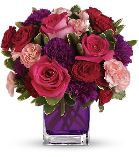 Bejeweled Beauty by Teleflora - Pure romance. Hot pink roses and dark red spray roses are brightly arranged inside our violet cube. Hot pink roses dark red spray roses purple carnations and pink miniature carnations are accented with assorted greens. Delivered in Teleflora's glass violet cube.Approximately 11 1/2" W x 11 1/2" H Orientation: One-Sided As Shown : TEV19-1ADeluxe : TEV19-1BPremium : TEV19-1C