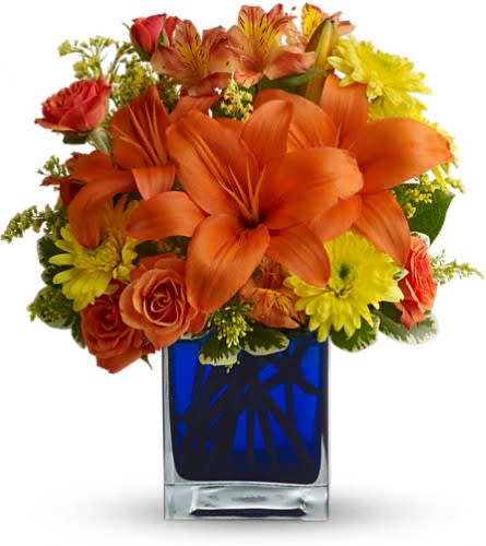 Summer Nights by Teleflora - Flower power rises several degrees in this brilliant array of hot summer flowers in a cool blue contemporary glass cube vase. Send this gift of indoor sunshine to someone close to you. The radiant bouquet includes orange Asiatic lilies orange alstroemeria yellow cushion spray chrysanthemums solidago and orange spray roses accented with assorted greenery. Delivered in a blue contemporary glass cube vase.Approximately 11 1/2" W x 13" H Orientation: All-Around As Shown : T05N441ADeluxe : T05N441BPremium : T05N441C