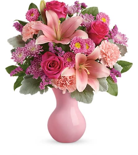 Teleflora's Lush Blush Bouquet - Inspired by the beautiful blush of happy cheeks this fabulous mix of roses lilies and carnations presented in a pink keepsake vase will make them feel like the extra special person they are! This pleasingly pink bouquet includes pink roses pink asiatic lilies pink carnations pink matsumoto asters lavender cushion spray chrysanthemums pink sinuata statice dusty miller and lemon leaf. Delivered in a pink plastic vase. Approximately 15" W x 17" H Orientation: One-Sided As Shown : TEV45-2A Deluxe : TEV45-2B Premium : TEV45-2C