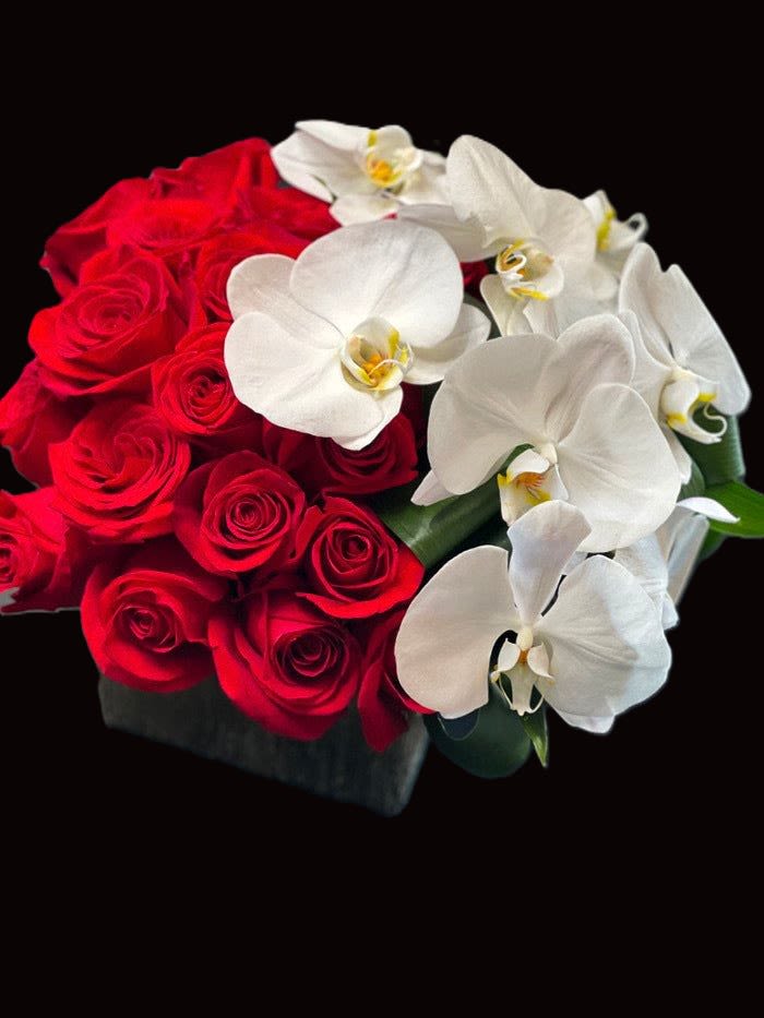 ORCHIDS AND ROSES - ROSES AND ORCHIDS AND GREENS IN A CUSTOM VASE