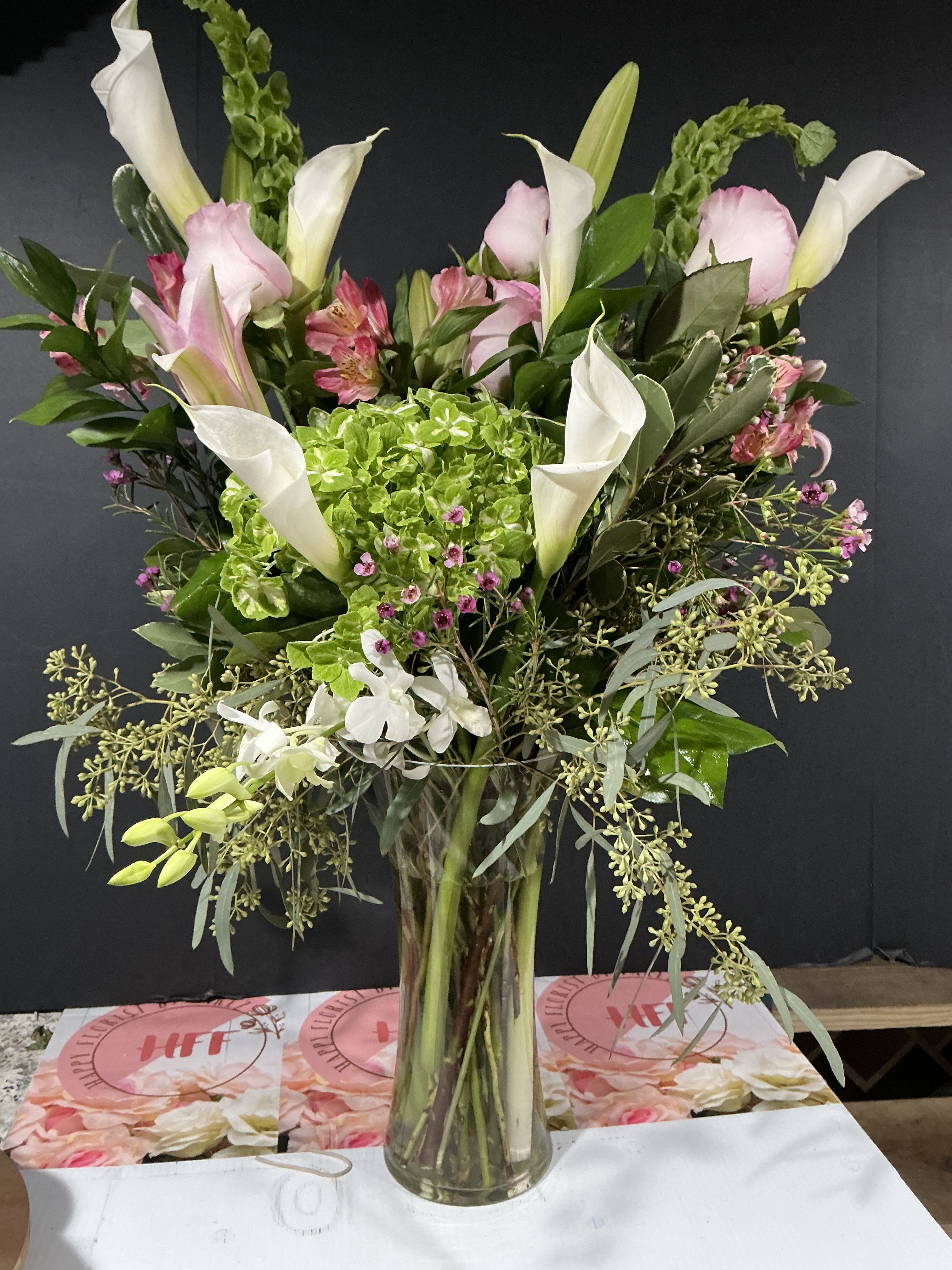 Simply Rustic  - Green hydrangea, bell's of Ireland, calla lilies, pink premium roses, dendrobium orchid, Asian lilies, wax flower, pink alstroemeria, snapdragon and greenery. This rustic color shows that Love  Prevails Forever 30H 25w