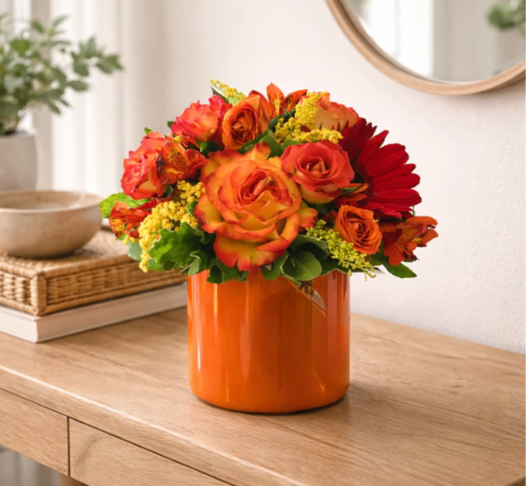 Sienna – Warm Sunset Floral Arrangement - Bring the warmth of a glowing sunset into any space with Sienna, a vibrant and uplifting floral arrangement designed by The Flower Boss in Sunland. Featuring radiant orange roses, fiery red gerbera daisies, golden filler blooms, and lush greenery, this design captures the essence of warmth, joy, and celebration.  Perfect for birthdays, congratulations, thank-you gifts, or simply brightening someone’s day, Sienna makes a bold and cheerful statement. Designed in a modern ceramic cylinder vase, this arrangement offers a stylish, contemporary look that complements any home or office décor.  Handcrafted with care and premium fresh flowers, each arrangement is thoughtfully designed to ensure beauty and longevity. Same-day flower delivery is available in Sunland and surrounding areas including Tujunga, Glendale, Burbank, La Crescenta, Pasadena, and nearby Los Angeles neighborhoods.  Perfect For: Celebrations, Get Well, Thank You, Just Because  Design Details: • Orange roses &amp; red gerbera daisies • Seasonal yellow accents &amp; fresh greenery • Modern ceramic cylinder vase • Designed in a compact, lush style  Tags / Keywords: Sunland florist, flower delivery Sunland CA, Tujunga flowers, Glendale florist, Burbank flower delivery, Pasadena florist, orange rose arrangement, modern floral design, birthday flowers, same day flower delivery Los Angeles, vibrant flower arrangement, The Flower Boss Sunland