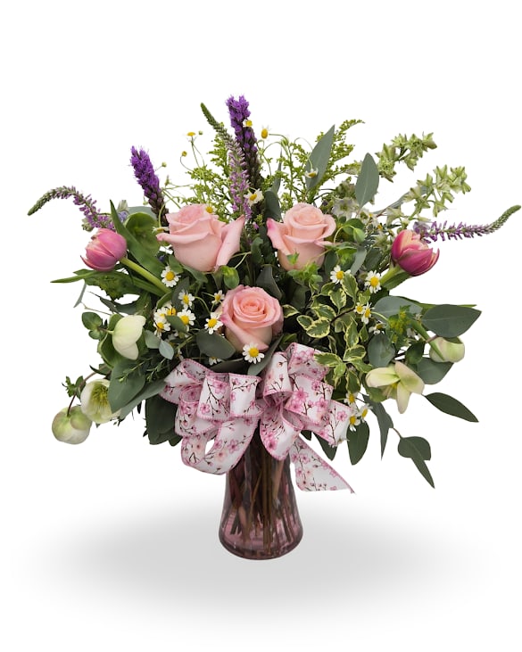 Daydream - Select this sweet garden-style arrangement featuring soft pink roses, playful blooms, and lush greenery, all gathered in a charming vase with a ribbon accent. Perfect for adding a light and lovely touch to any space. Approx. 20" x 16" x 20"