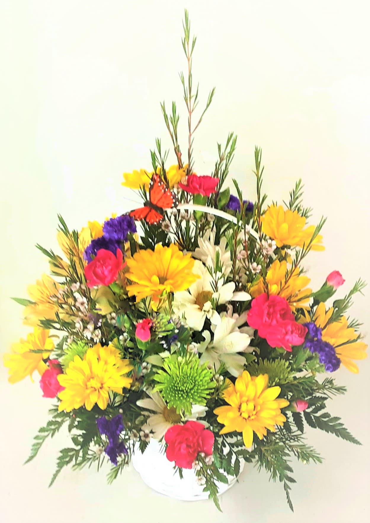 Colorful mixed flower arrangement in a white basket