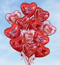 Balloon Bouquets - I Love You - A playful cluster of shiny red heart-shaped balloons that say "I Love You" makes an immediate, romantic statement - ideal as a Valentine's Day surprise, anniversary gift, or spontaneous token to remind the person you're thinking of how much they mean. The metallic hearts catch the light, reflecting highlights of pink and white patterns that give the bouquet a lively, celebratory feel your recipient will notice the moment it arrives.  This arrangement features multiple red foil heart balloons printed with romantic script and accented by lighter pink and white edge designs, each tied with curling balloon ribbons to form a cohesive, floating bouquet. The glossy surfaces and bold red tones create a striking visual contrast that pairs beautifully with a bouquet of roses or a box of chocolates if you choose to add extras.  Perfect for partners, sweethearts, or anyone you want to make feel cherished, this balloon bouquet sends a clear, affectionate message without words. Balloons arrive ready to display; avoid sharp objects and keep them away from heat sources to preserve their shine. Order for pick-up or local delivery in Fort Myers to ensure they arrive on the special day.