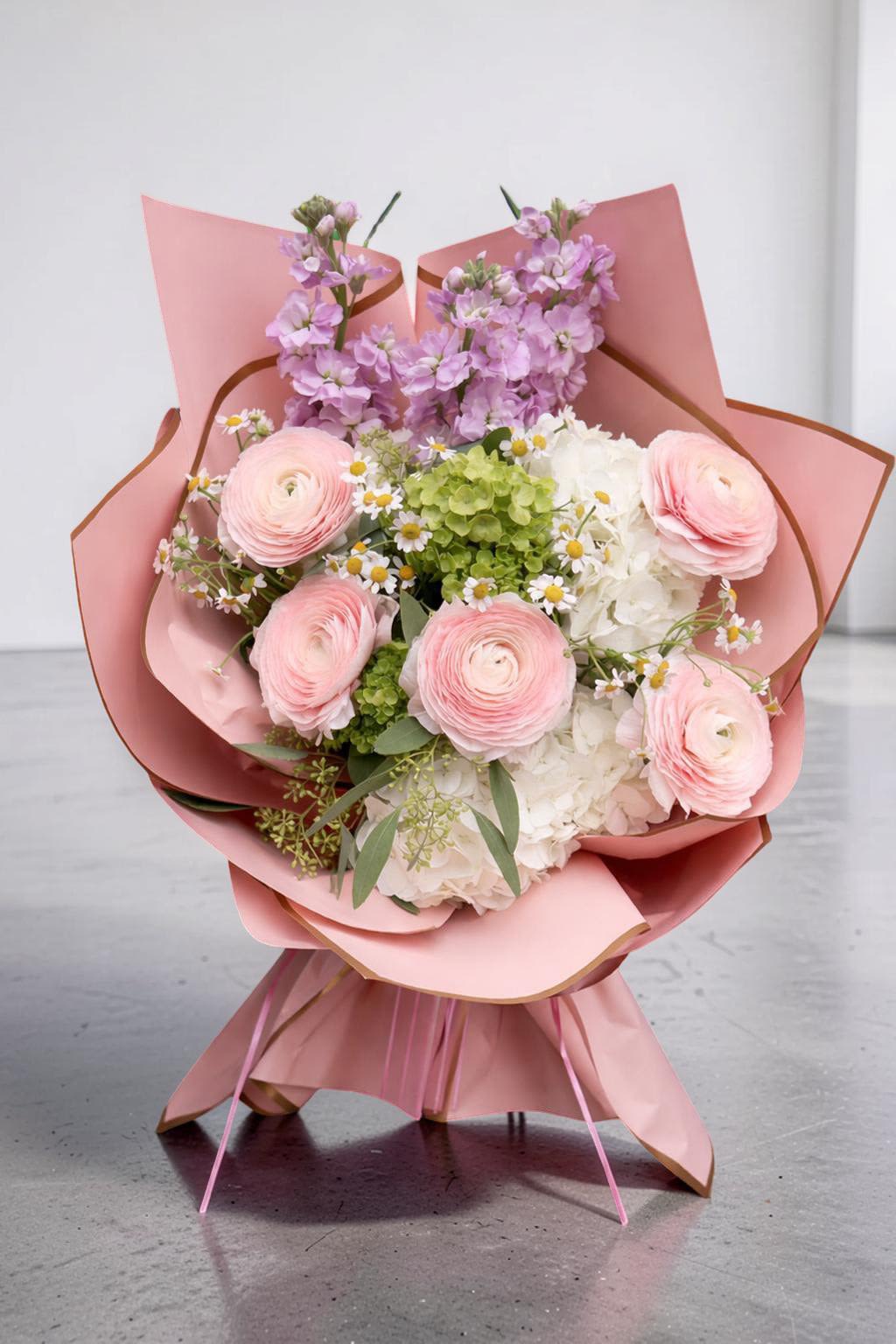Morningside Bloom Wrap - A soft and elegant hand-wrapped bouquet designed especially for Columbia University graduates. Featuring delicate pink ranunculus, lush white hydrangeas, fresh greenery, and charming mini daisies, this bouquet is wrapped in blush-toned paper for a clean, modern look.  Light, joyful, and full of beautiful texture, it is the perfect way to celebrate a proud achievement and make graduation day feel even more special.