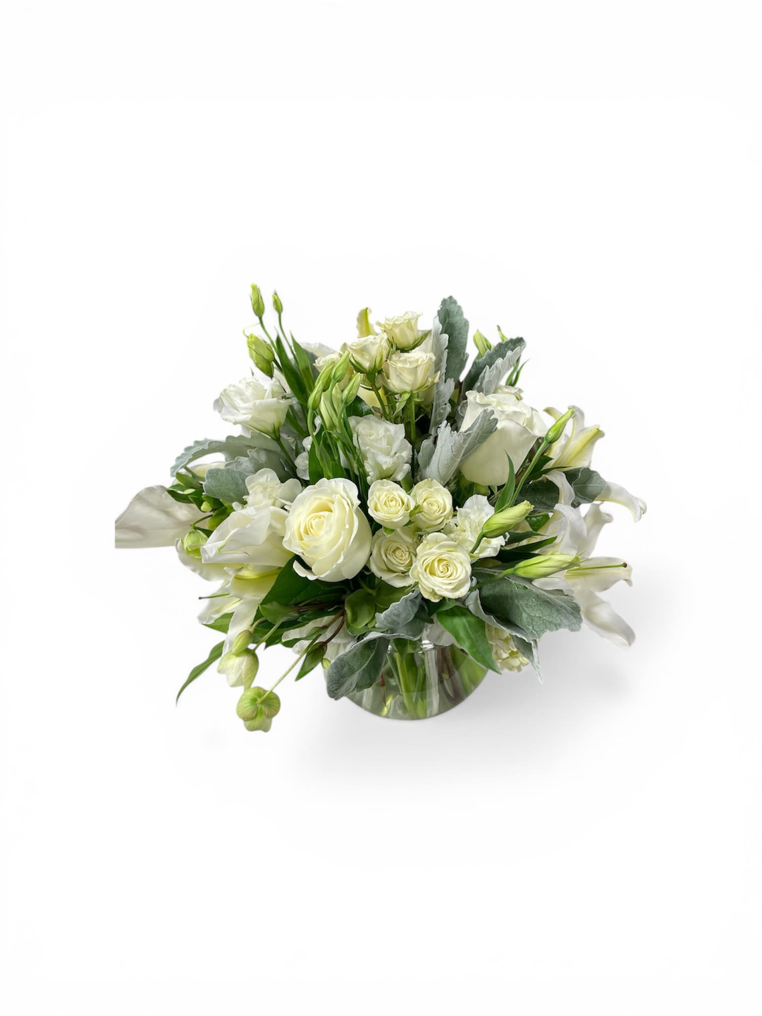 Petal Perfection‘s Wondrous White - Creamy white roses, fragrant lilies, and delicate lisianthus form a serene, rounded bouquet that reads as calm elegance - perfect as a sympathy arrangement, anniversary flowers, or a refined Mother's Day gift. This white flower arrangement also suits weddings, thank-you gestures, and "just because" moments when you want the person you're thinking of to feel comforted and truly seen.  The compact design clusters roses, spray roses, lilies, and lisianthus closely for a lush, tactile look, with soft green buds woven in to add subtle contrast. Blooms are presented in a simple clear glass vase that keeps the focus on texture and form; the clean lines make it equally at home on a bedside table, mantel, or dining centerpiece. Sized to be both intimate and impactful, it's a tasteful choice for Easter, graduations, housewarmings, sympathy and funeral services, or holiday and seasonal gift-giving.  Easy to care for: refresh the water every 2-3 days, recut stems at an angle, and keep out of direct heat to extend vase life. Available for same-day delivery when ordered early, it's a graceful way to mark birthdays, get well wishes, weddings, retirements, and other meaningful milestones.