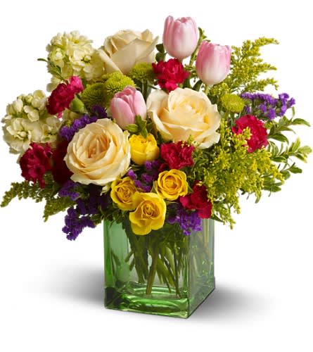 Springtime Harmony - Peach roses, pink tulips and other fabulous favorites in a sleek contemporary cube vase - what a breath of spring! Send this gorgeous bouquet to someone special and prepare for a non-stop thank-you.     The charming bouquet includes peach roses, pink tulips, hot pink miniature carnations, solidago, green button spray chrysanthemums, light yellow stock, purple statice and yellow spray roses accented with fresh greenery. The flowers are delivered in a stylish green glass cube vase. Bouquet is approximately 13â W x 13â H 