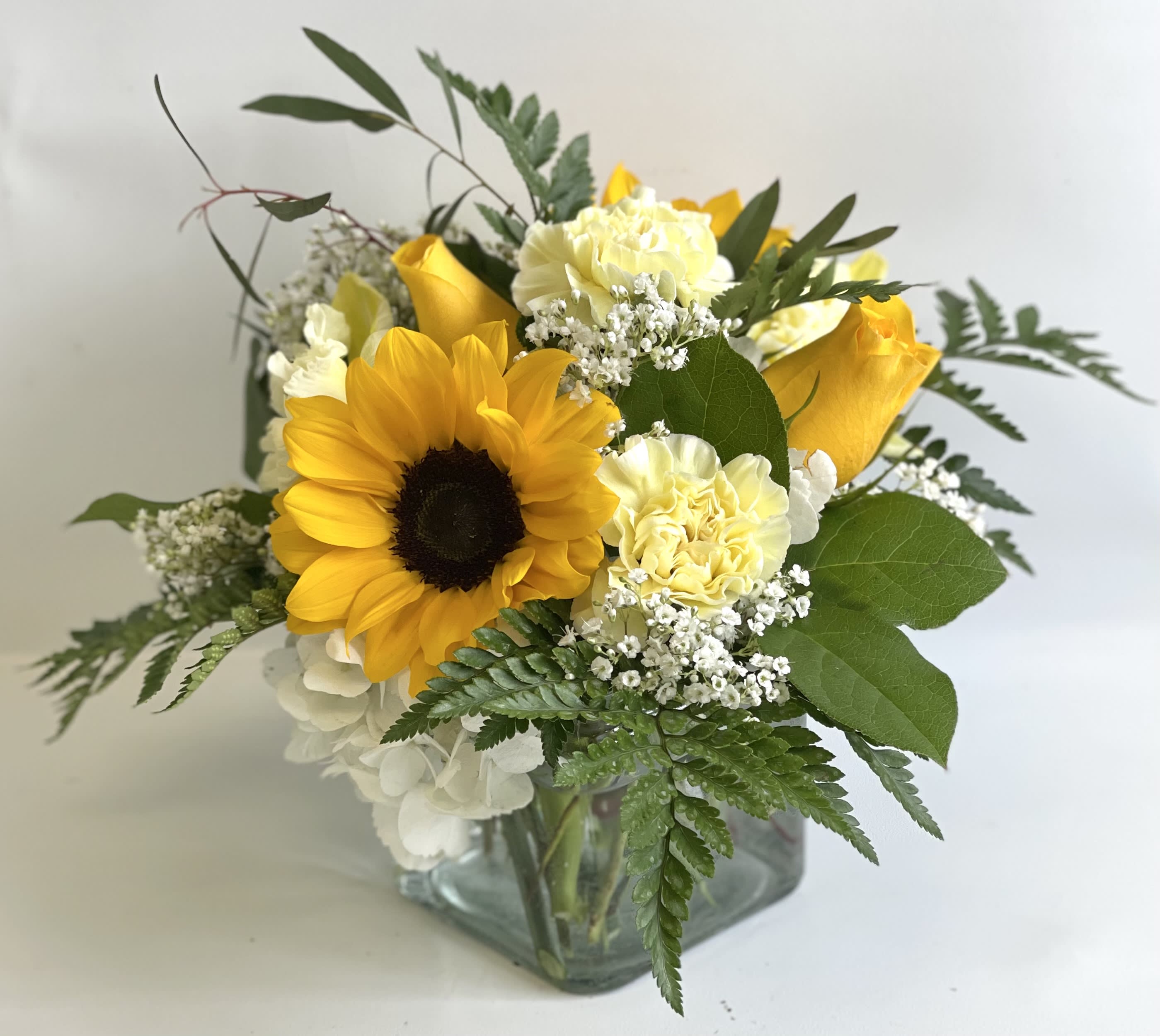 Sunflower and yellow rose bouquet in a square glass vase