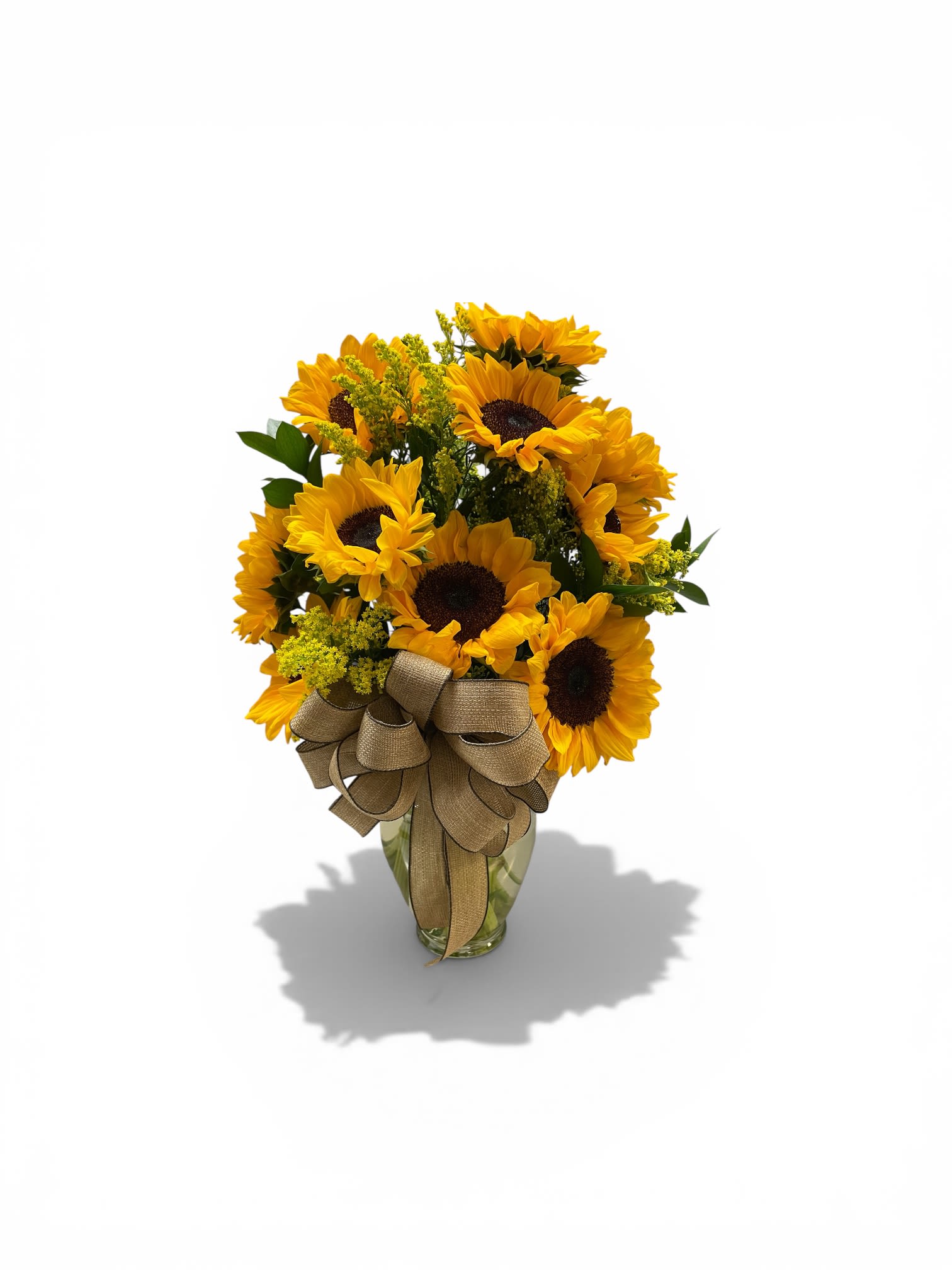 Sunflower Frenzy  - Bold, golden sunflowers with deep black centers take center stage in this sunflower bouquet-an ideal birthday bouquet, get well arrangement, or sunny housewarming gift that also fits Mother's Day, Father's Day, or just-because moments. The bright yellow petals and contrasting dark disks give the design an immediate, uplifting presence that makes the recipient feel genuinely seen and celebrated, whether you're sending summer cheer, Easter smiles, or a warm "thinking of you."  A generous cluster of sunflowers is arranged with soft yellow filler blooms and green foliage in a clear glass vase, finished with a large burlap-style ribbon bow for a casual, rustic touch. The texture of the petals and foliage creates volume and movement, while the glass vase keeps the look fresh and modern. Sized to brighten a kitchen table or bedside, this arrangement needs fresh water and a trim of stems every few days to keep blooms at their best.  Perfect for birthdays, graduation, retirement, Thanksgiving host gifts, or as a cheerful sympathy pick-me-up after a tough day, this bouquet works year-round-especially lovely for spring and summer celebrations. Order with next-day delivery where available to surprise someone with an instant lift.