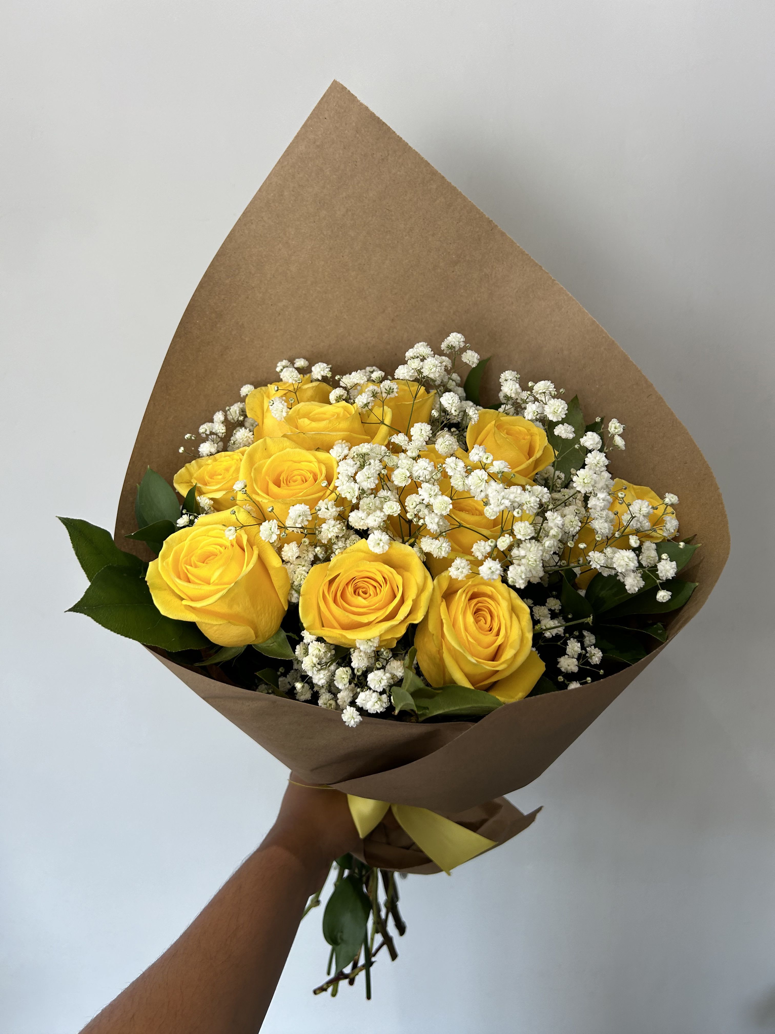 Friendship Bouquet  - 1 dozen yellow roses arranged into a hand-tied bouquet with baby's breath and green foliage. 