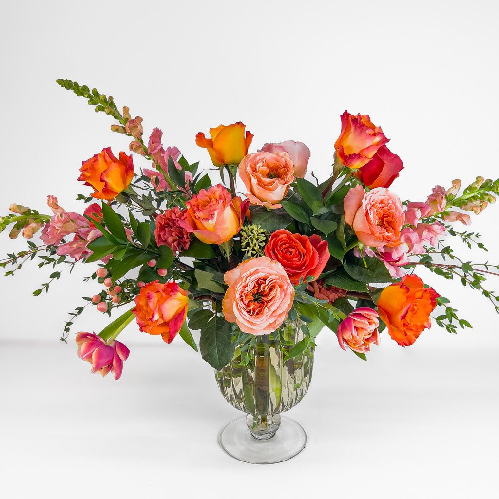 Afterglow - Sunset-hued blooms come together in a garden inspired arrangement that feels vibrant, radiant, and effortlessly romantic. 