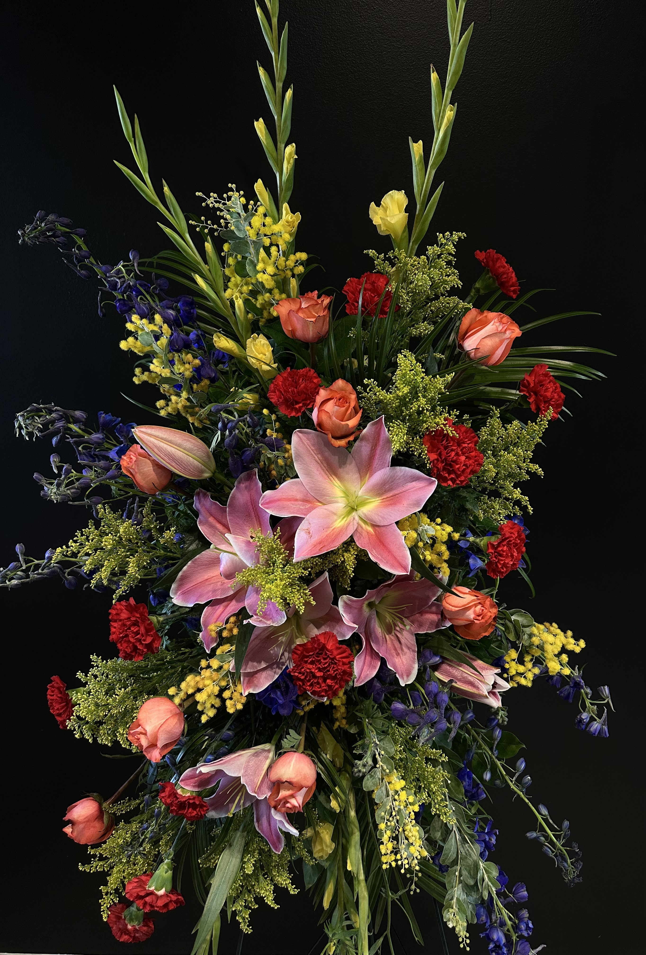 Sympathy - Standing Spray full of varying vibrant and soft shades, encorporating a mix of various of flowers. 