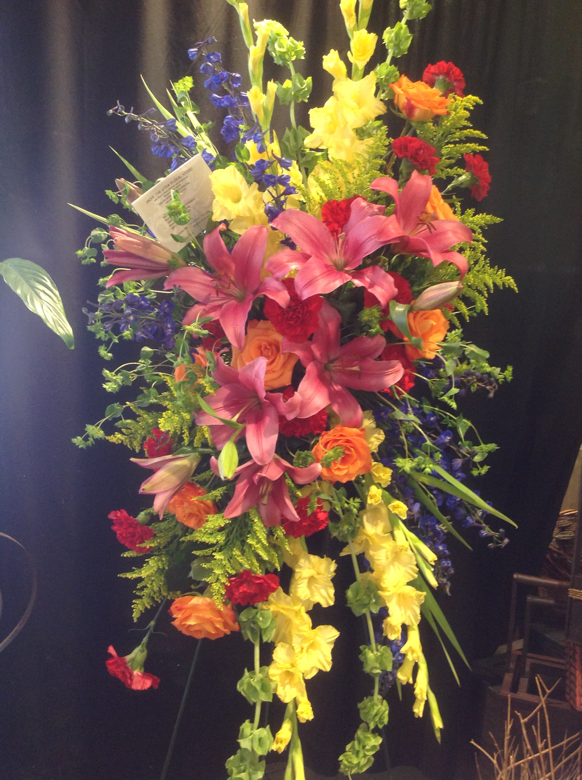 Comfort - Colorful rainbow themed standing spray.  Please contact our shop for custom orders.  *Flowers subject to change based on supply*