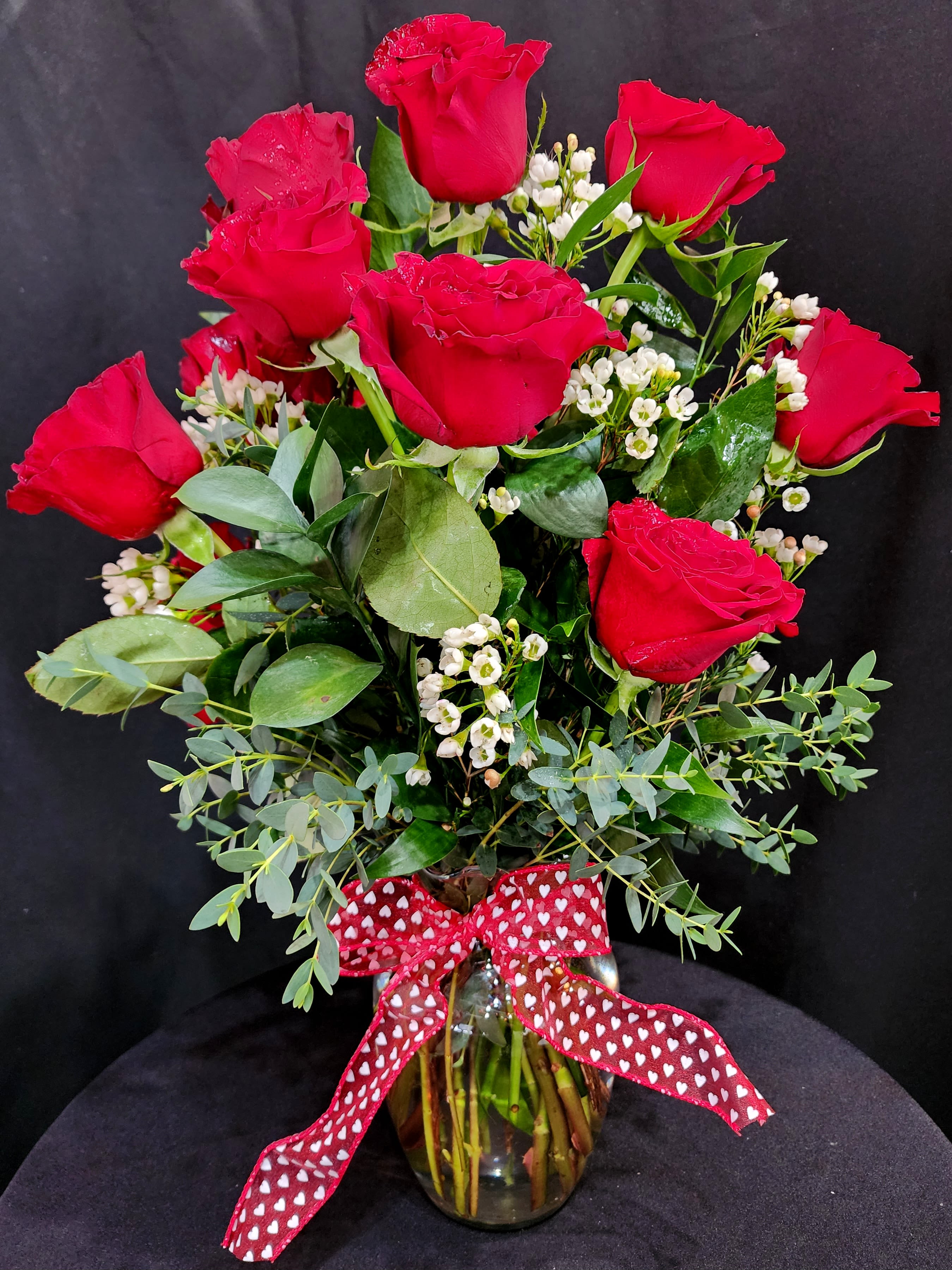  Large Roses by the Dozen - 1 dozen large roses in a vase for the classic souls. Eriostemon (when available) foliage and Wax flowers  which has an incredible scent-citrusy &amp; fruity. Approximately 24" high in an 8.5" vase. Please call, text, email or put in special instructions for other available colors and containers. 2 dozen = Deluxe 