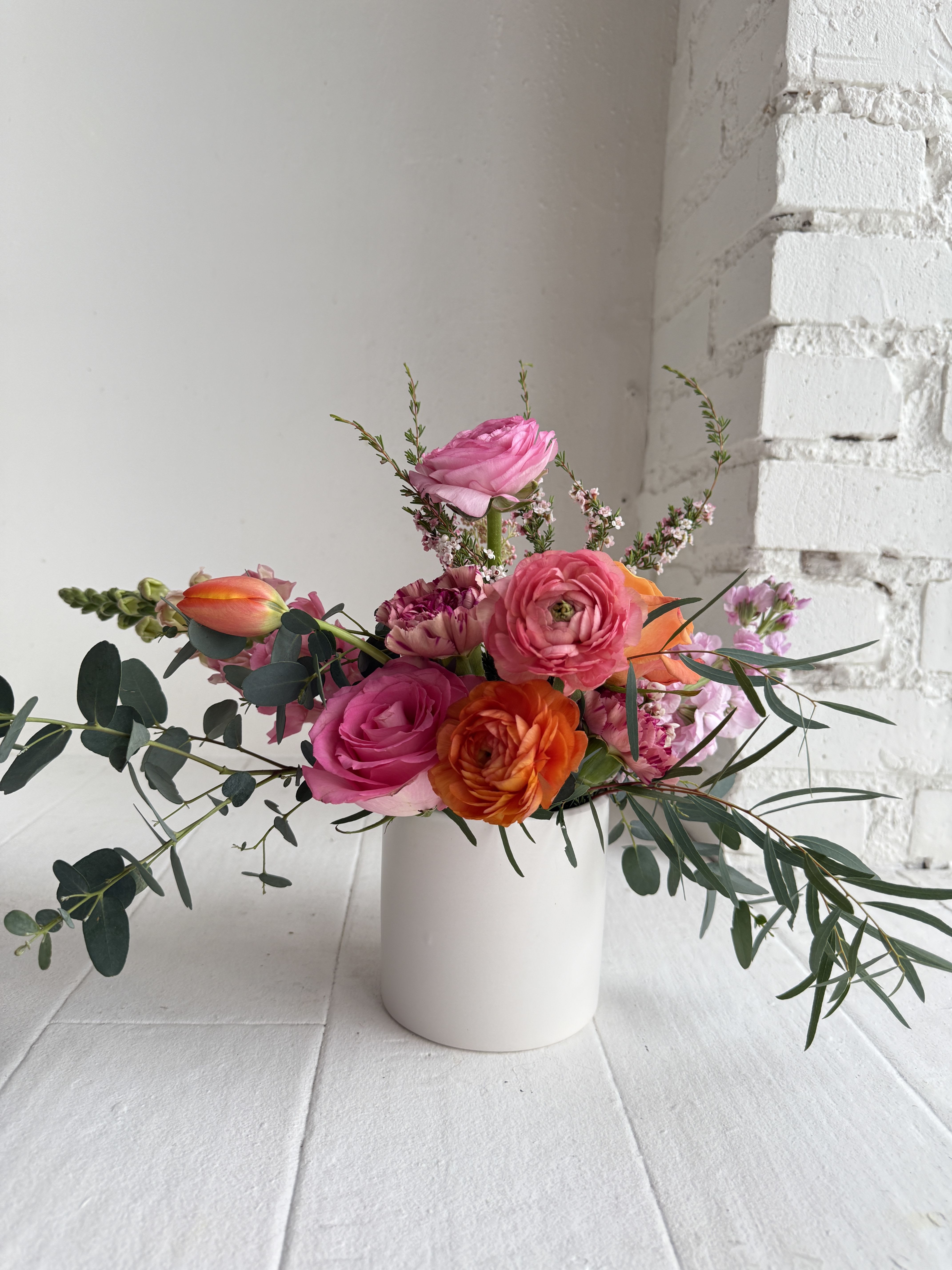 Lottie - We artfully arrange blooms in bright bold shades of orange, pinks and peach to create a lush garden style arrangement. Favoring seasonal and as many locally grown varieties as possible. Peonies, ranunculus, stock, heirloom mums, lisianthus, poppies, roses.