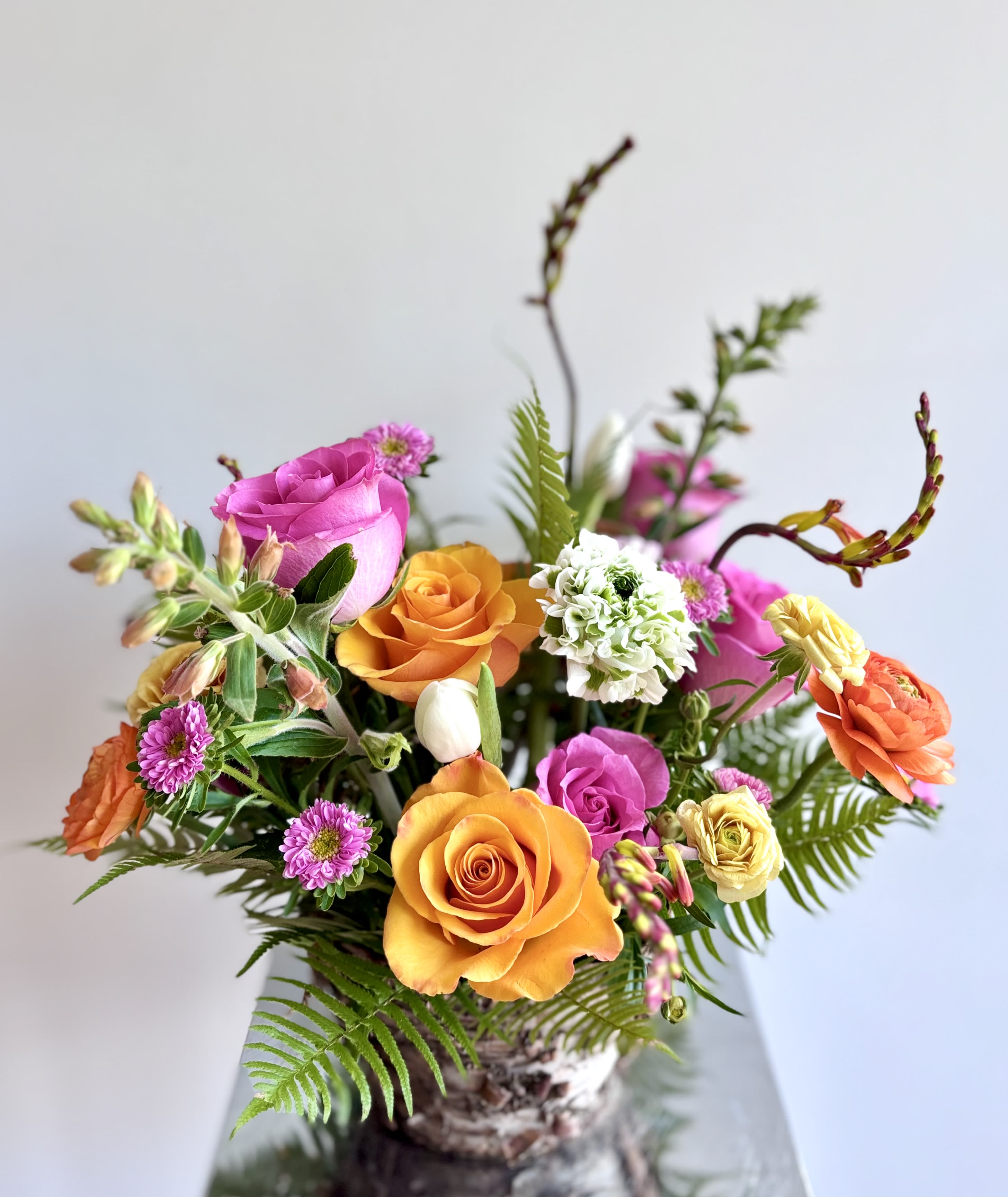  Easter Flower Basket - A  colorful celebration of Easter and all the things called spring. A fun flower arrangement in a birch basket/pot with a mix of spring flowers twigs. The selection and colors and flowers may vary based on the availability but rest assured our designer will sneak the favorite floral goodies like tulips, daffodils, poppies, anemones.