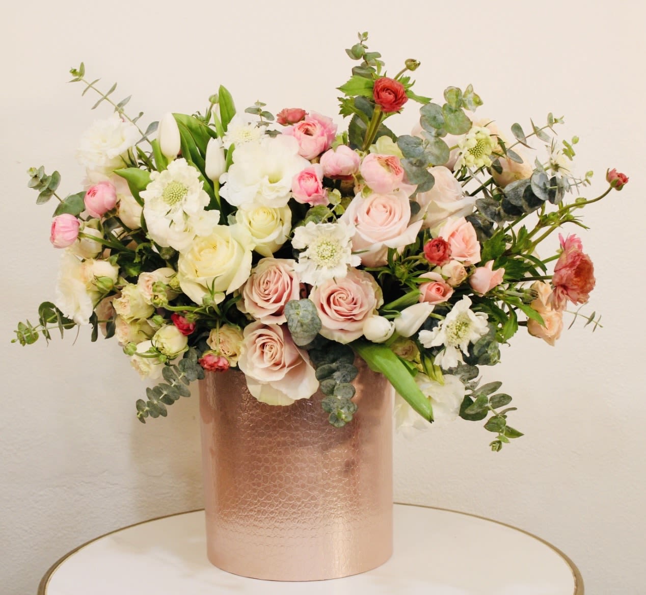 Champagne Bloom - Celebrate timeless elegance with our Champagne Bloom, a refined floral design featuring premium roses, ranunculus, and seasonal blooms in soft blush, ivory, and champagne tones. Arranged in a modern textured gold vase, this piece brings a sophisticated and luxurious presence to any space. Its soft romantic palette and balanced design make it perfect for birthdays, celebrations, or upscale gifting. Each arrangement is handcrafted with premium flowers to deliver a high-end floral experience with attention to every detail. Same-day flower delivery available across: Beverly Hills, Bel-Air, West Hollywood, Beverly Grove, Culver City, Hollywood Hills, Hollywood, Santa Monica, Brentwood The arrangement shown in the photo is the Deluxe size.