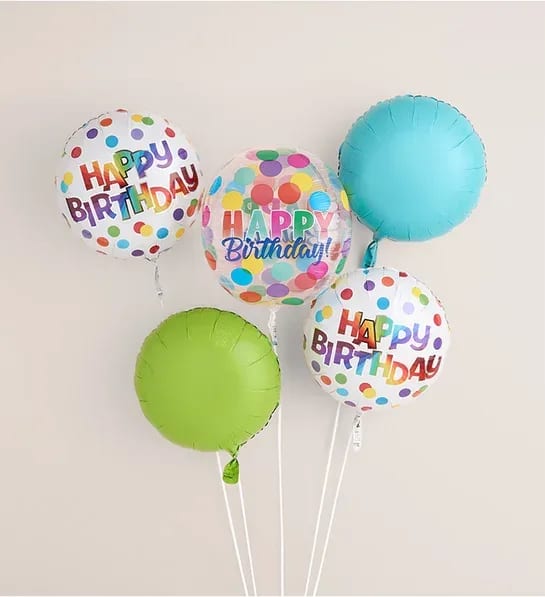 Cluster of colorful birthday balloons with polka dots and "Happy Birthday" text