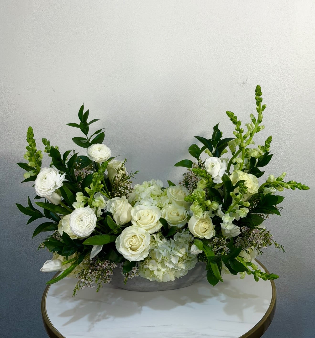Ivory Luxe Garden - Elevate any space with our Ivory Luxe Garden – a sophisticated floral arrangement featuring premium white roses, ranunculus, hydrangeas, and seasonal blooms, beautifully accented with fresh greenery. Designed in a modern low vase, this arrangement offers a clean, refined, and luxurious look that suits any occasion – from celebrations and romantic gestures to elegant home styling. Each arrangement is handcrafted at Guy Floral Studio with exceptional attention to detail and a passion for floral artistry, ensuring a unique and high-end floral experience. We proudly offer same-day flower delivery in West Hollywood, Beverly Hills, Bel Air, Beverly Grove, Santa Monica, Culver City, Hollywood Hills, and surrounding Los Angeles areas. The arrangement shown in the image is the Deluxe size.