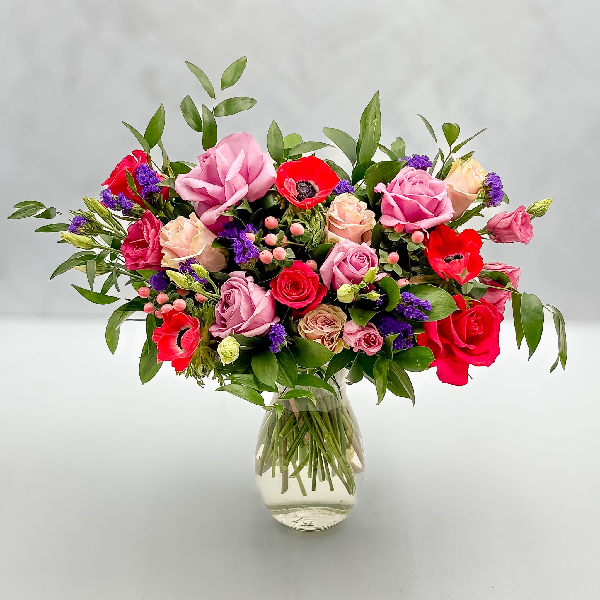EMILY IN PARIS - This colorful, front facing arrangement was created by our own "Emily in Paris" (Caity). A mix of upscale greens, different color roses, lisianthus, anemonies and more.