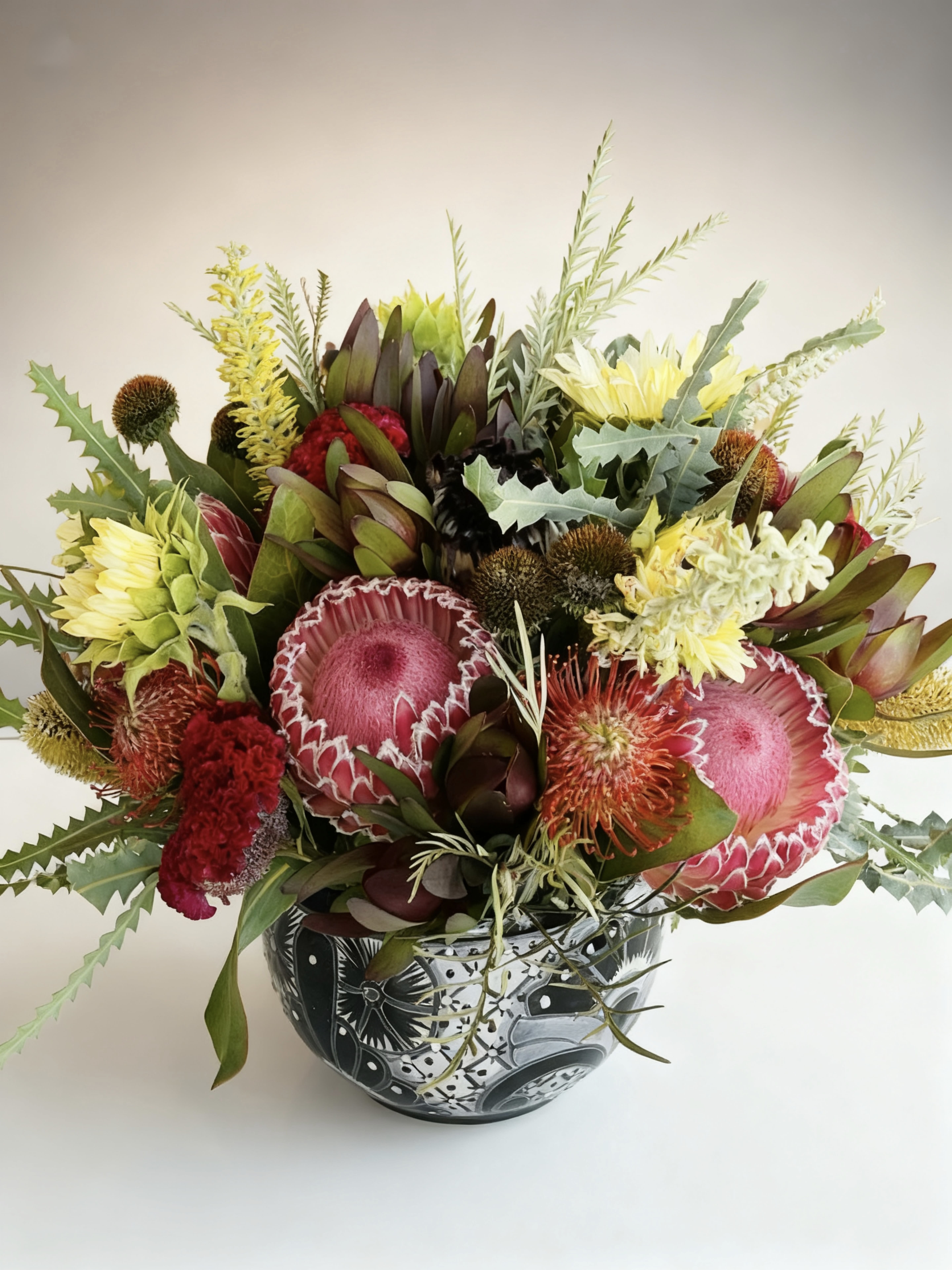 For the Love of O'side - A show-stopping display of locally sourced, floral and foliage. Perfect when you want that wow factor.  Black and white Talavera pot hand painted and made in Mexico. Patterns will vary. Shown in premium.