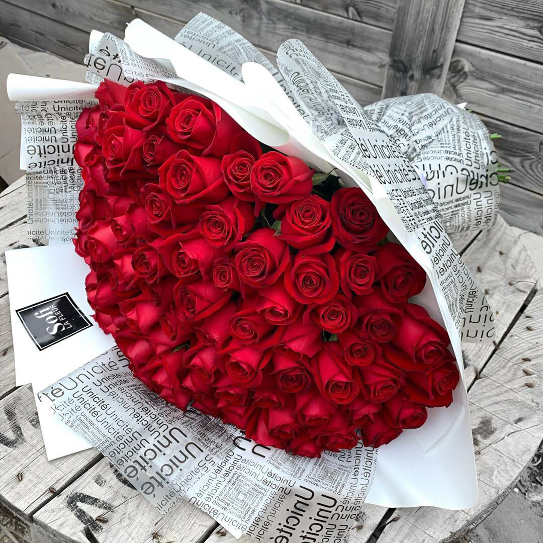 100 XOXO - Classic Hand-Tied Red Rose Bouquet - Elegance in Every Stem  Celebrate love and elegance with our hand-tied bouquet of fresh red roses, carefully arranged to perfection. Each bloom is hand-selected for its vibrant color and velvety petals, creating a timeless display of beauty. Ideal for anniversaries, romantic gestures, or any special occasion, this bouquet exudes sophistication and charm.  Order now and let the timeless beauty of roses make any moment unforgettable! Color of roses may be changed by request.   *Vase not included*   