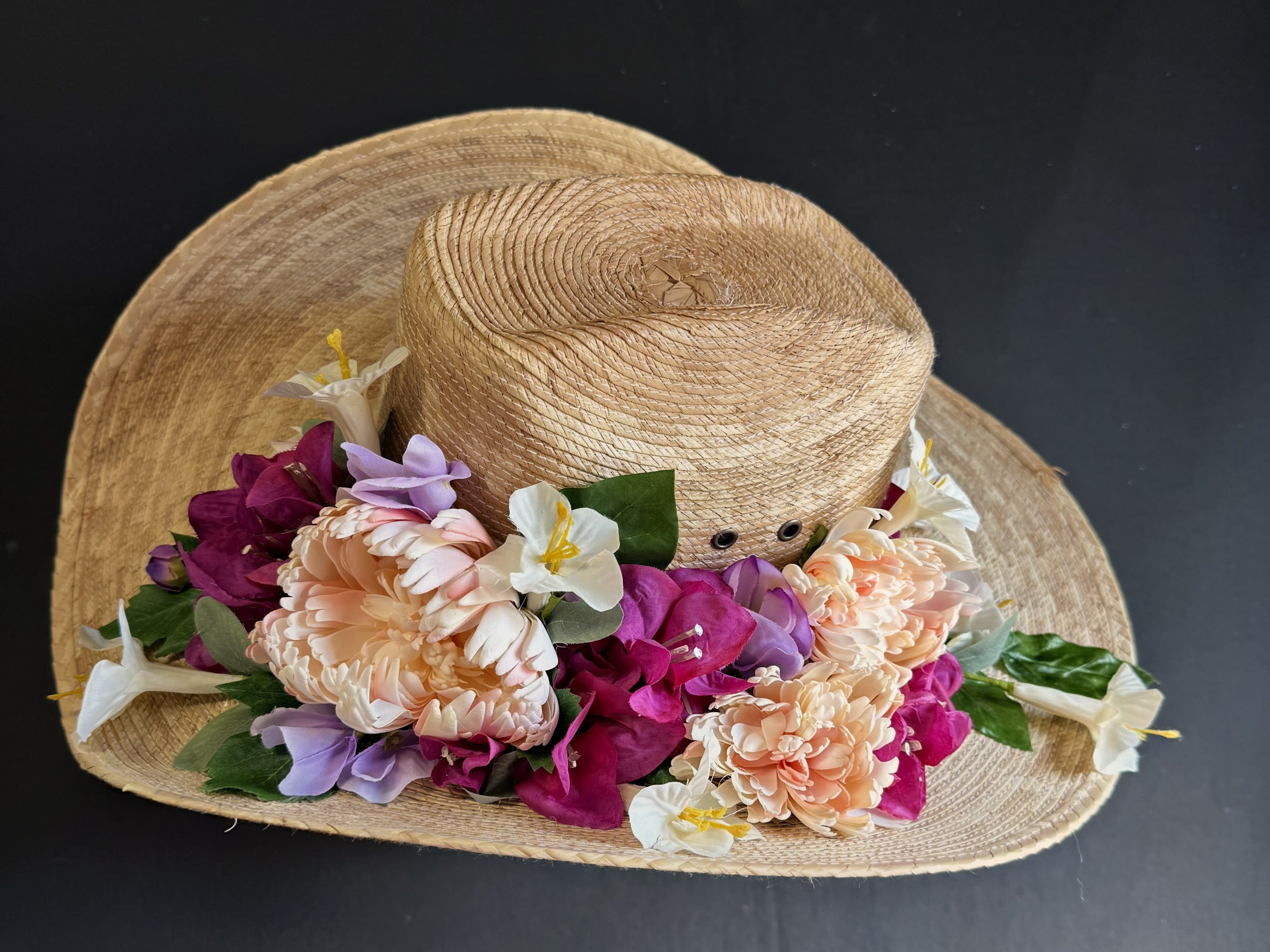 Blush Meadow Keepsake Hat				 - A whimsical straw hat adorned with faux florals and delicate greenery. Designed as a decorative accent, this piece is perfect for spring displays, tea parties, bridal showers, or boutique wall décor.				 				 				