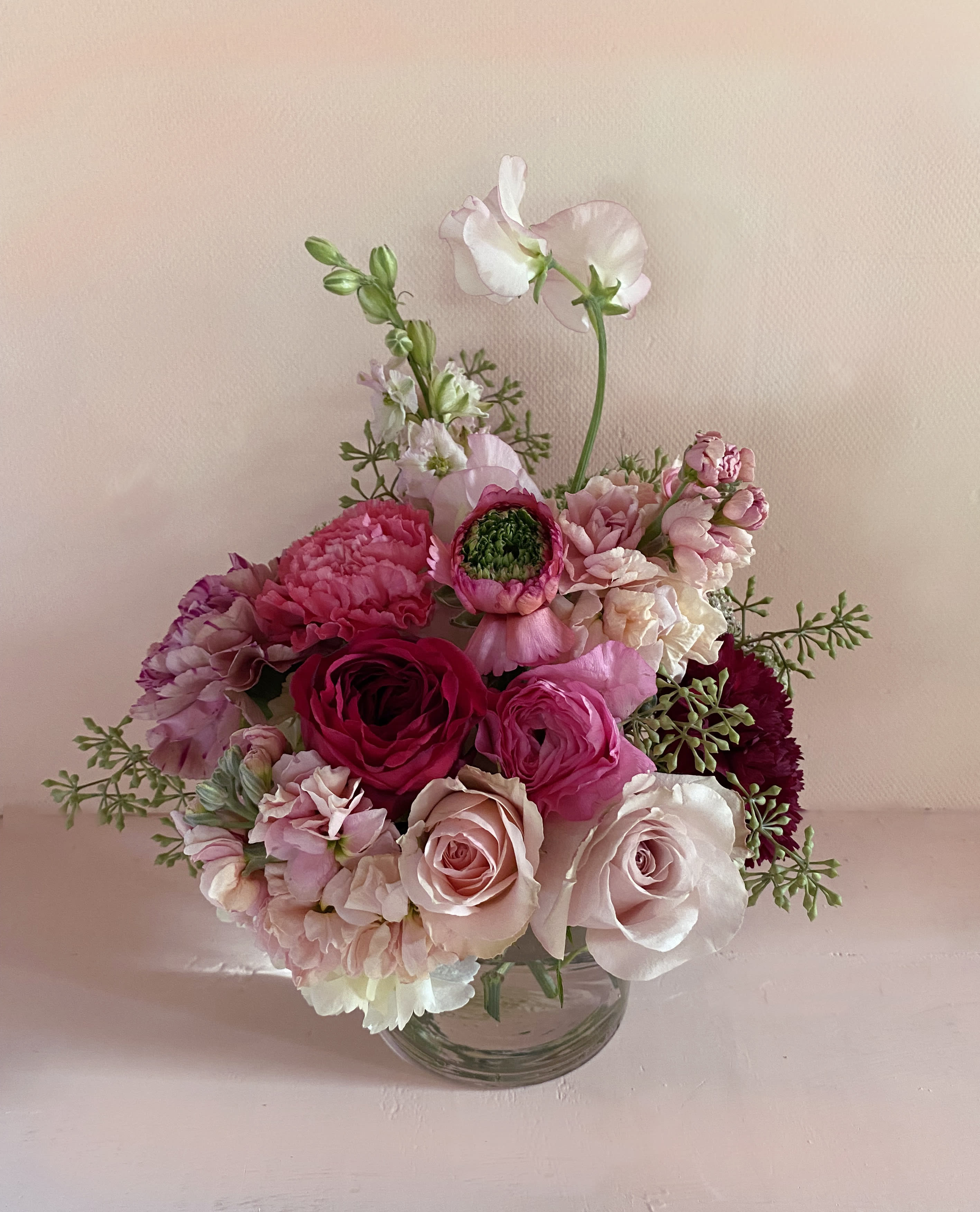 The LOVE - Adorable arrangement of all the Valentines love colors and flowers. Sweetpeas, roses, ranunculus, stock and carnations arranged in a clear cylinder 4" by 4" vase. It's not a large arrangement but it holds all the love and will make a beautiful statement. Add chocolate, tea or beauty products at check out, hand delivery in LA