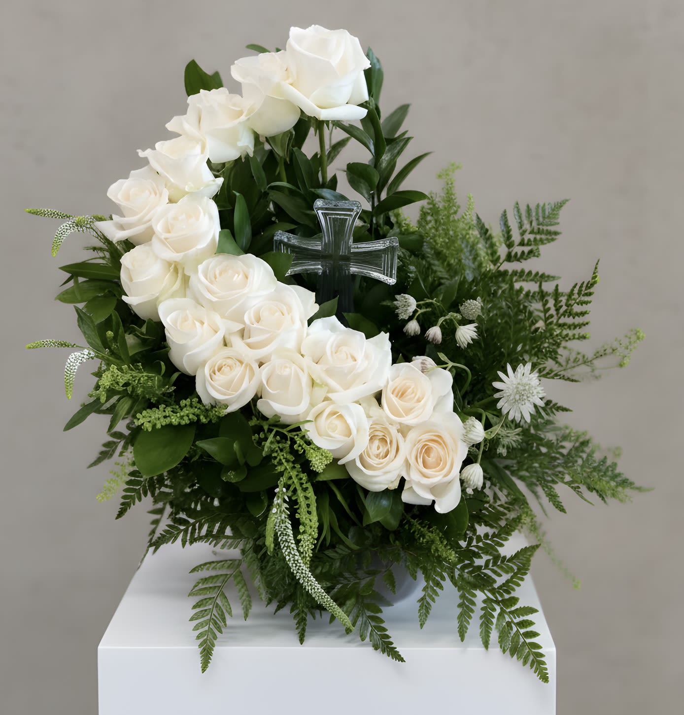  Heavenly Rose Tribute with Crystal Cross - Honor your loved one with grace and beauty. The Heavenly Rose Tribute features a lush bed of premium roses, delicately arranged to surround a keepsake crystal cross. This elegant design symbolizes peace, faith, and eternal love, offering comfort and a meaningful way to remember someone special. Ideal for services, memorials, or graveside tributes.