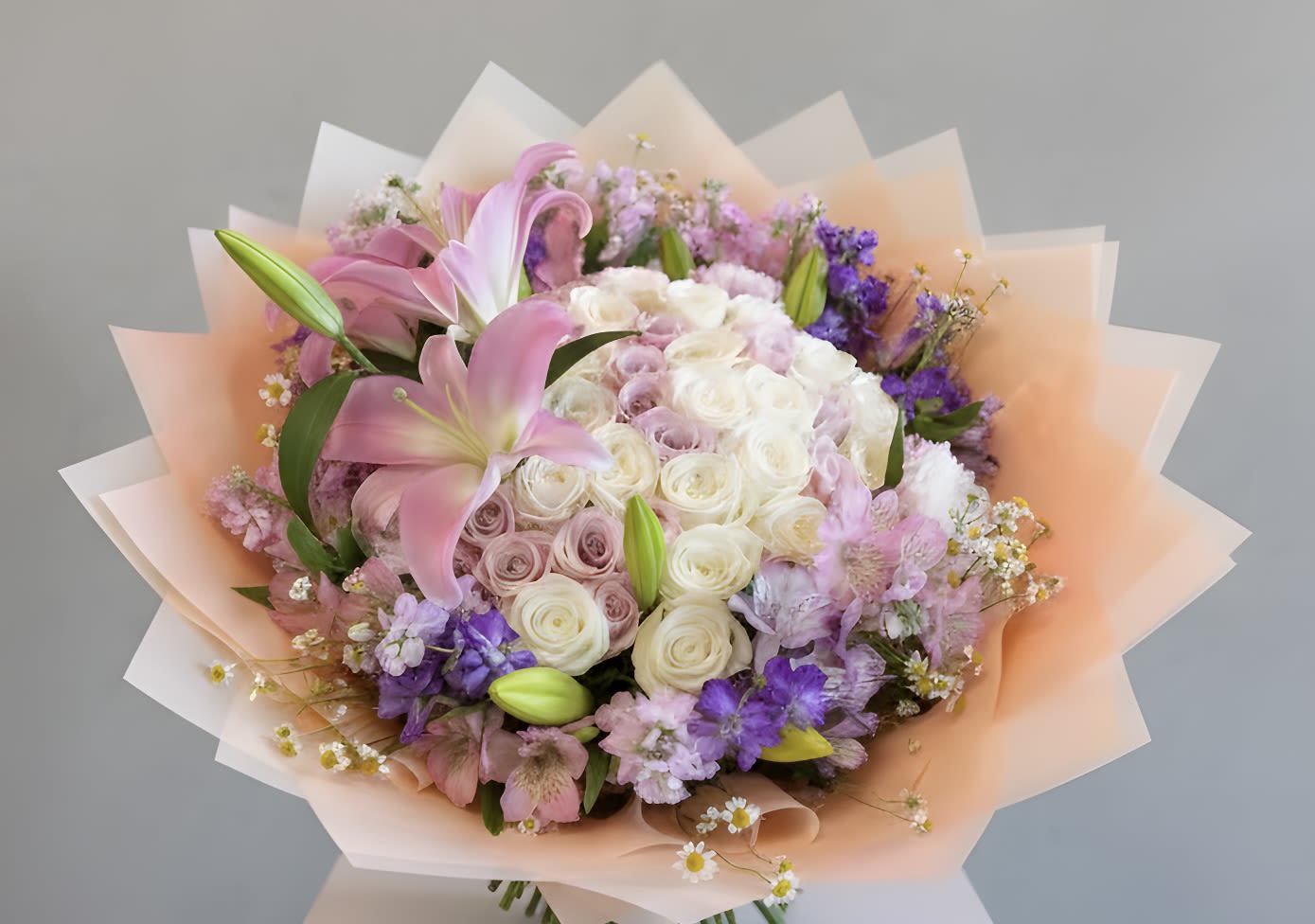  Pastel-Colored Roses and Flowers Bouquet - This exquisite bouquet features an enchanting array of pastel-colored roses, each blossom radiating a soft and delicate beauty. The roses and flowers are artfully arranged to create a harmonious and serene palette. Standard comes with 24 roses and seasonal flowers Deluxe comes with 36 roses and seasonal flowers Premium comes 50 roses and seasonal flowers
