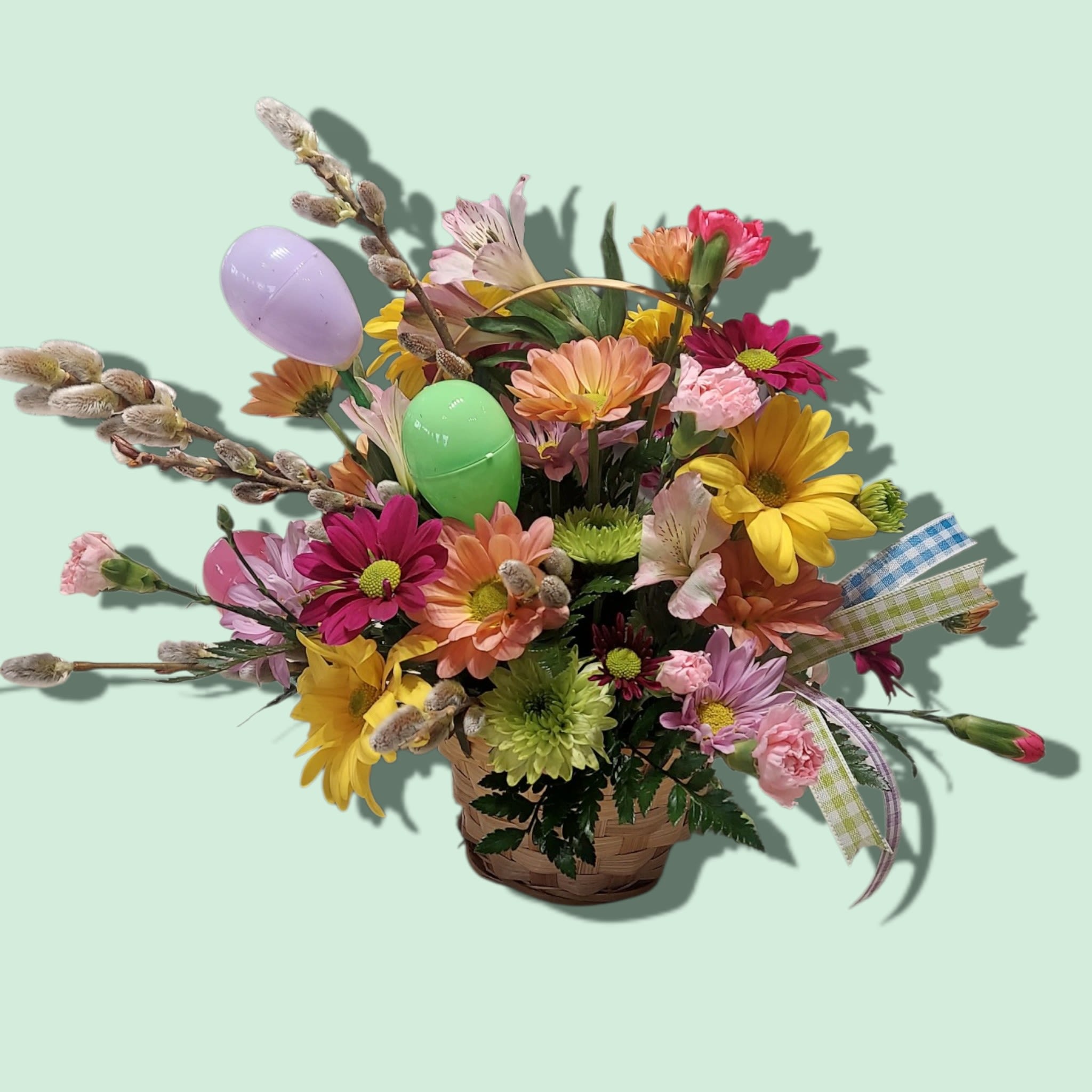 Bunny Trail Basket - Brightly colored blooms adorned with Easter eggs, pussy willows and ribbon. COLORS WILL VARY WITH AVAILABILITY. Approximate size 10" x 10".