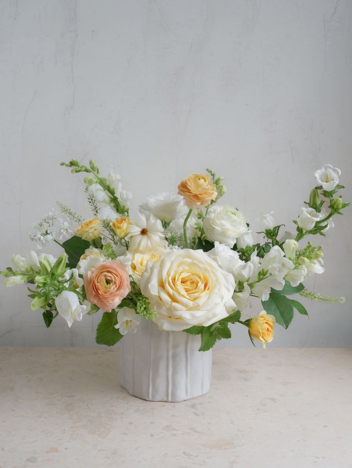 Madeleine - White, pale buttery yellow, and peach color palette with magnificent blooms such as garden roses and ranunculus. 