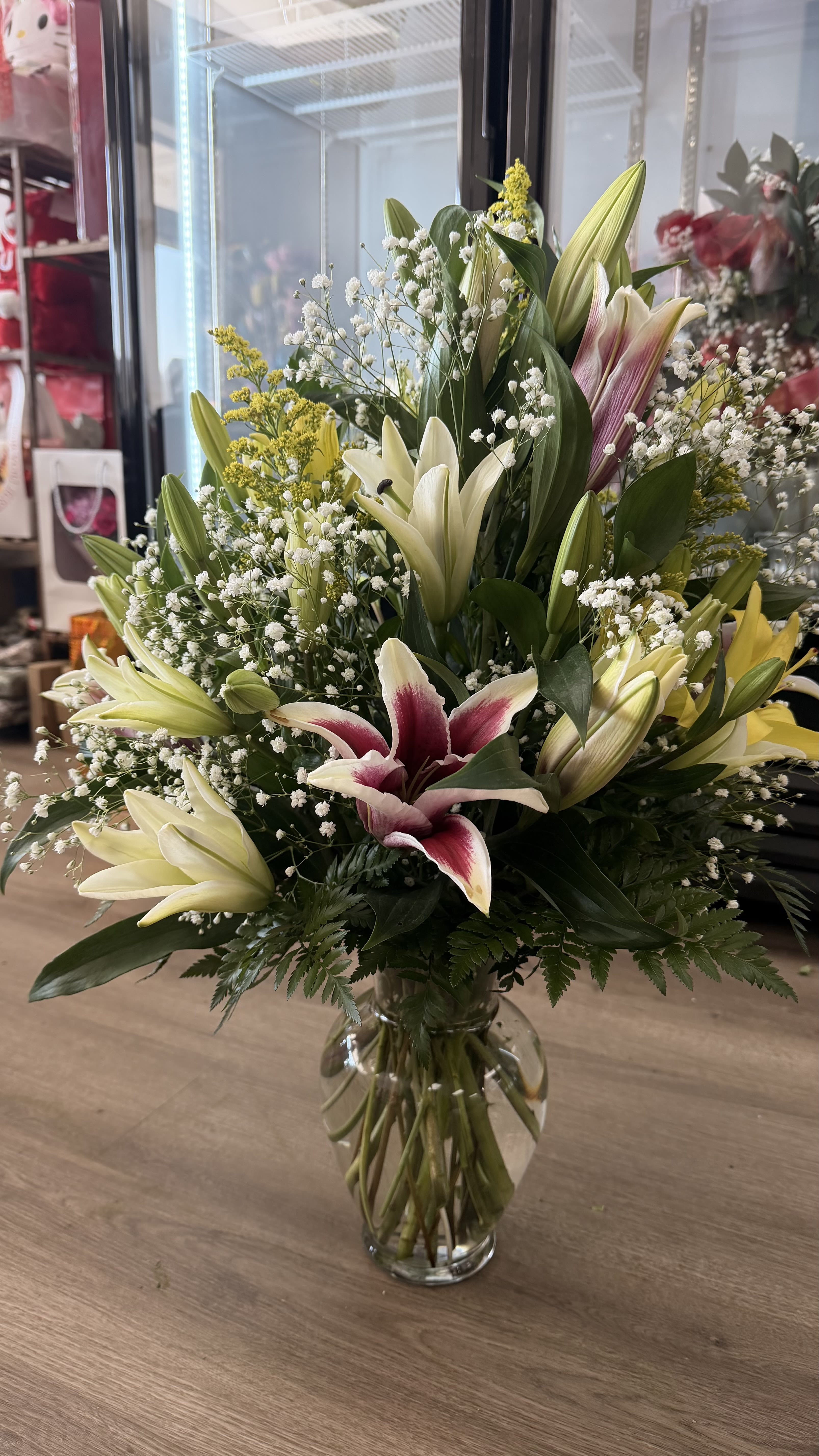 Large bouquet of lilies and baby's breath in a clear glass vase