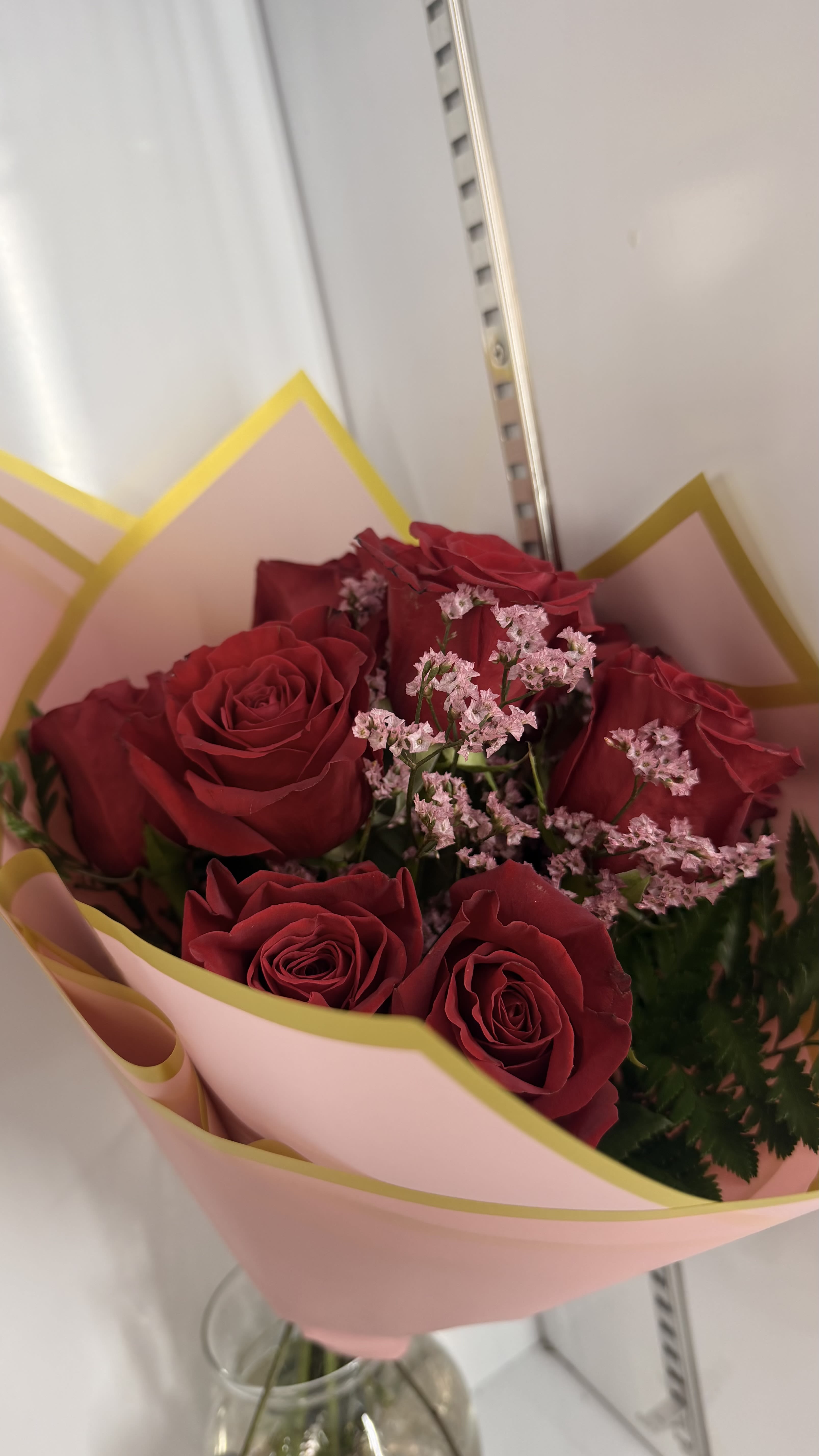 Bouquet of red roses with pink filler flowers in pink wrapping