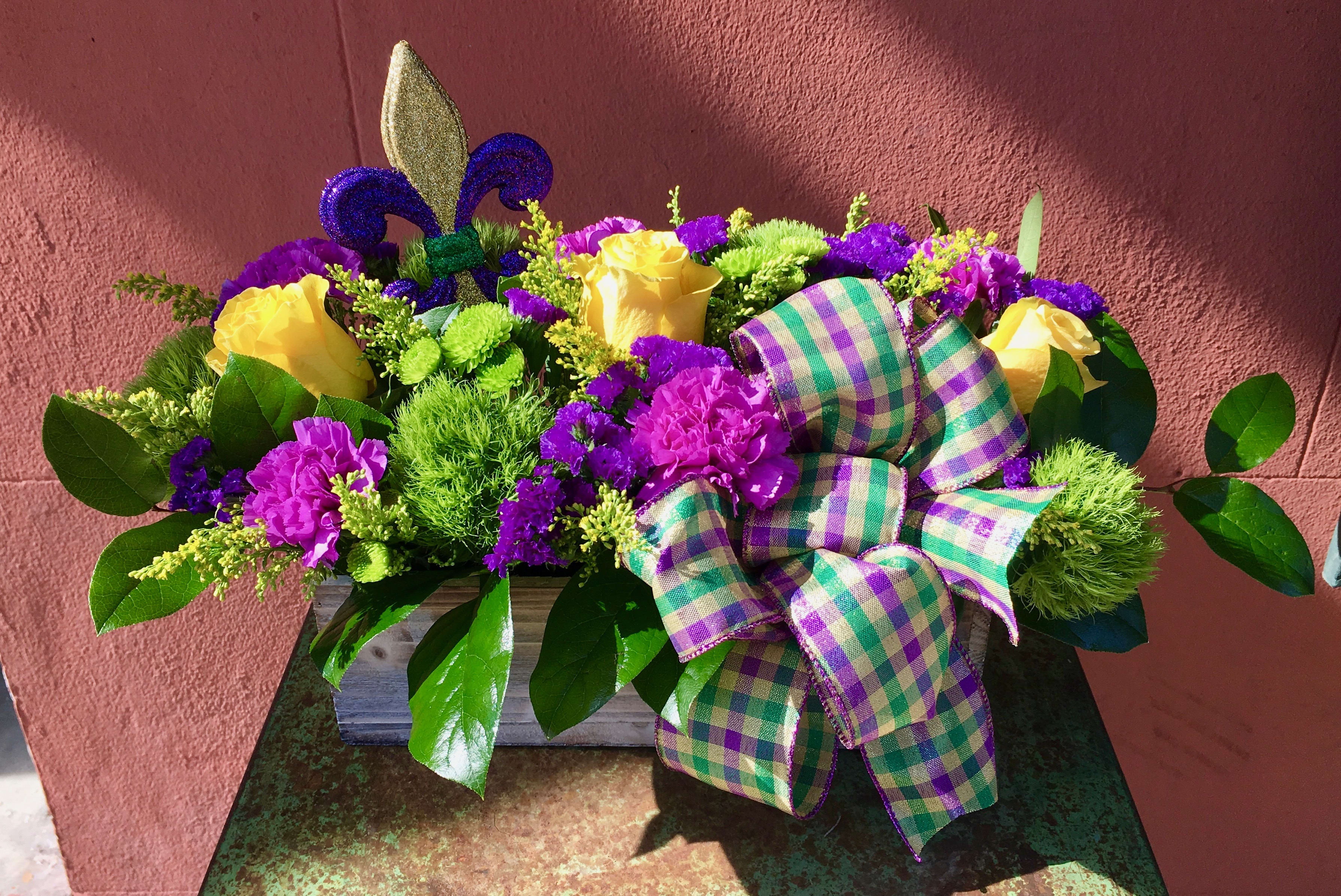 Yellow roses and purple flowers in a wooden box with a plaid ribbon