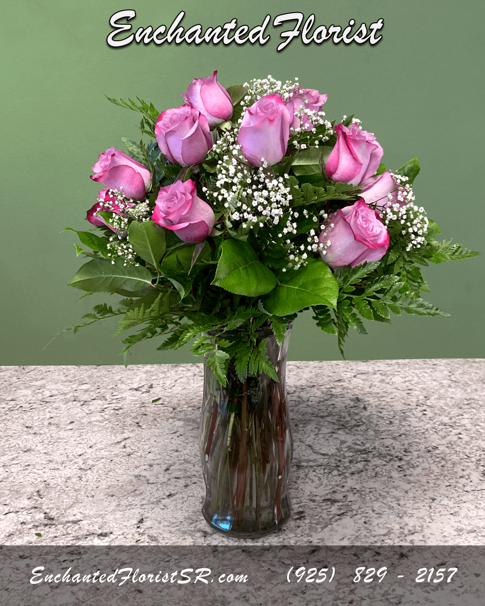 Tall glass vase of pink roses with white filler flowers
