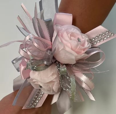 Festive Rose Prom Corsage - Two pink roses with festive ribbon for a extra added touch of elegance. The deluxe version includes a matching boutonniere. The roses and bow can come in a variety of colors, include color choice in the notes if ordering online