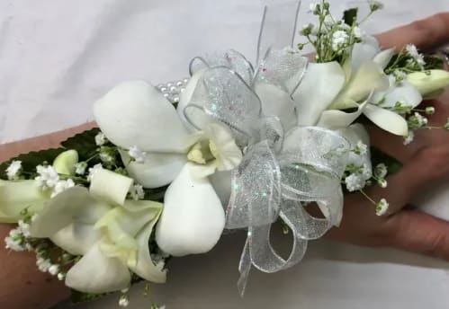 Orchids w/ Babies Breath Corsage - White orchids with babies breath corsage. The deluxe version includes a matching boutonniere. The roses and flowers can come in a variety of colors, include color choice in the notes if ordering online. it also can come in fresh or silk flowers.