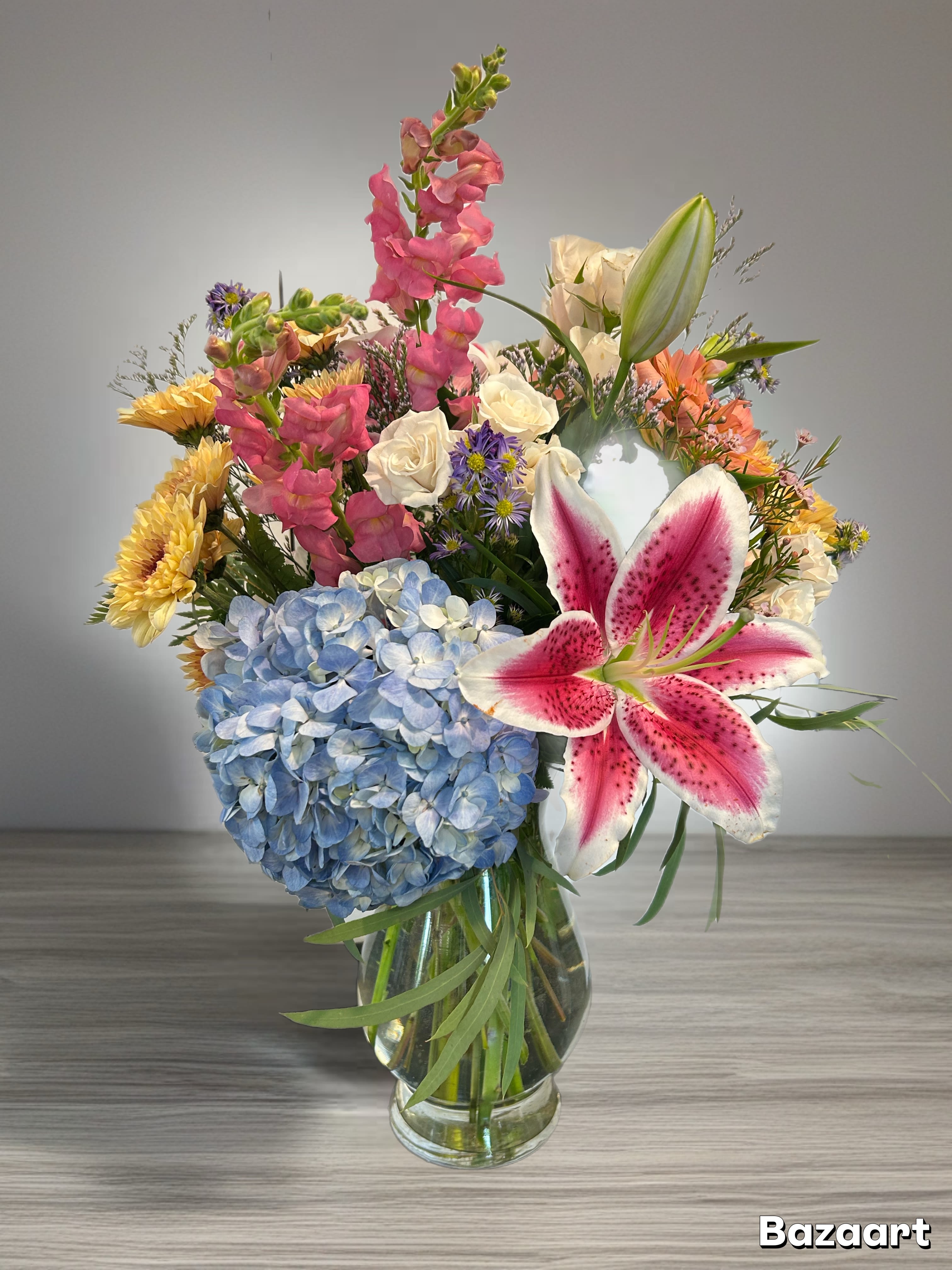 Mixed bouquet in a glass vase with blue hydrangea and pink lily