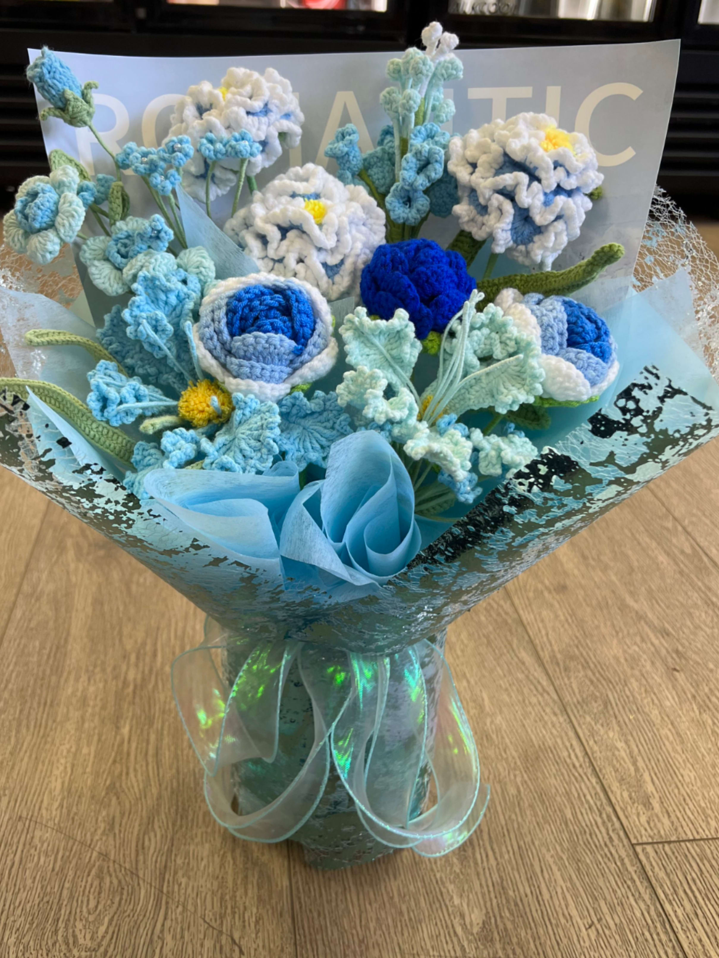 Blue crochet bouquet - A bouquet of intricately hand-knitted blue flowers, featuring delicate petals creating a charming and lasting floral arrangement.