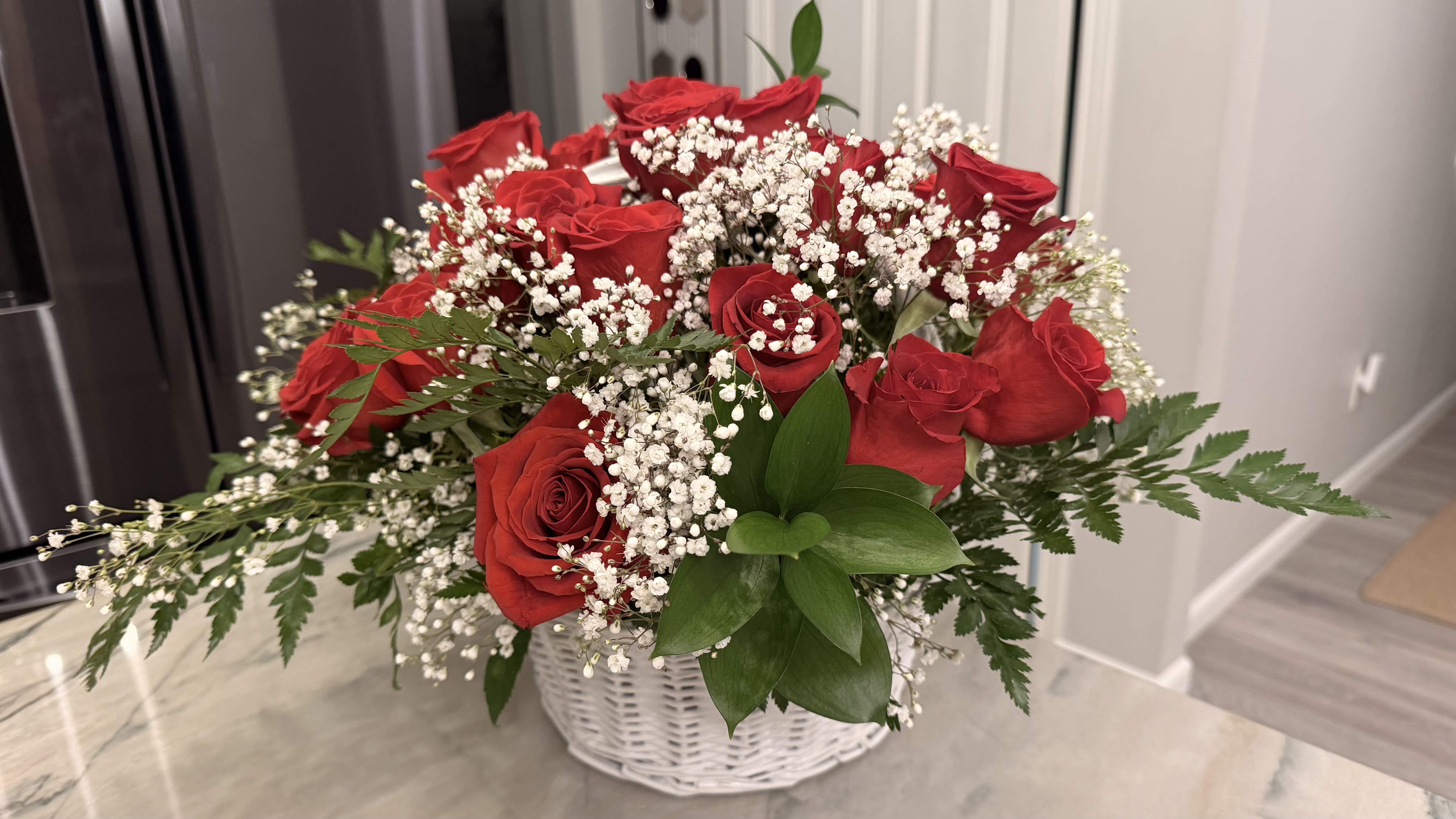 Red roses and baby's breath in a white basket