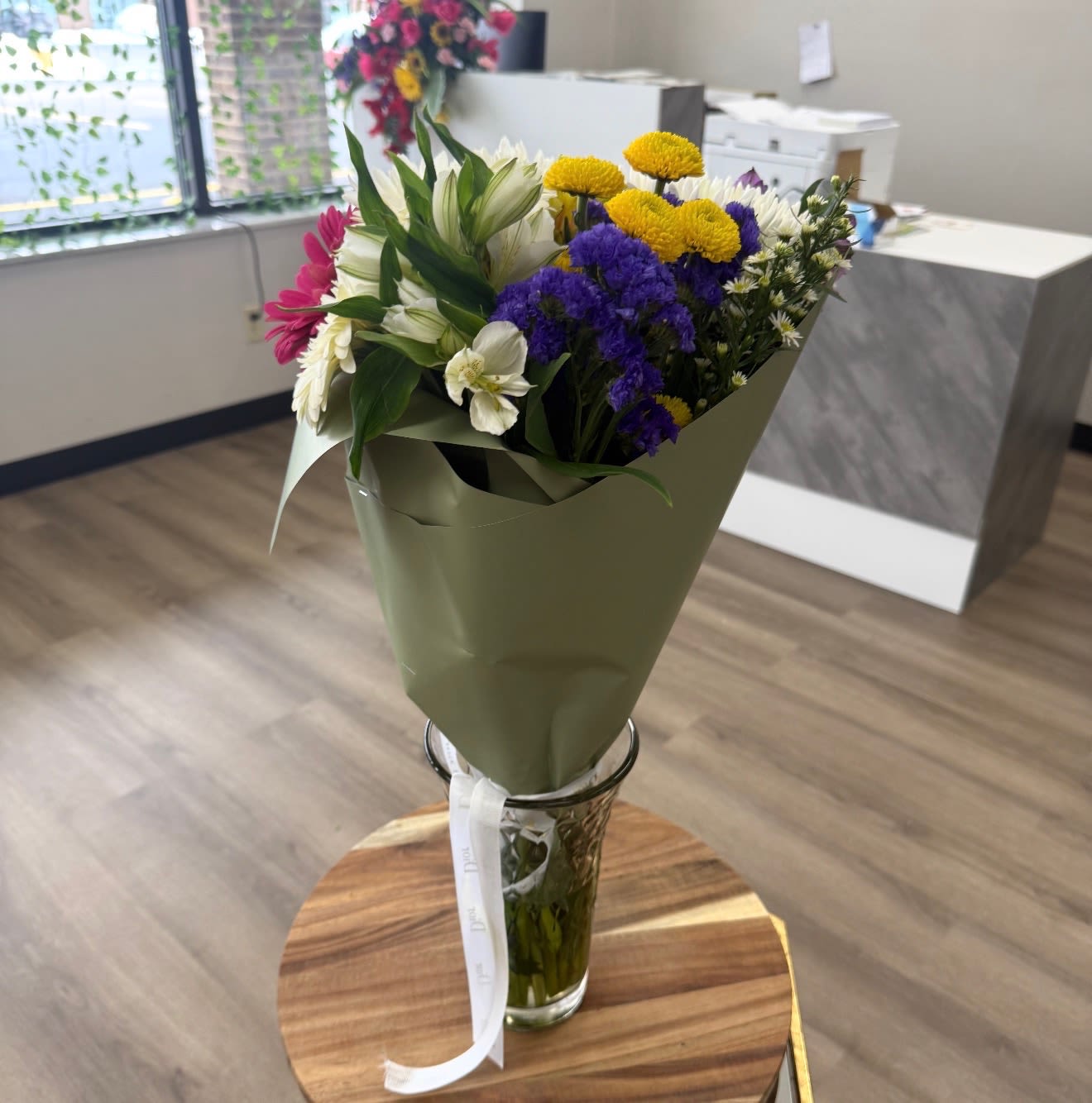 Mixed bouquet of white, purple, yellow, and pink flowers in a glass vase