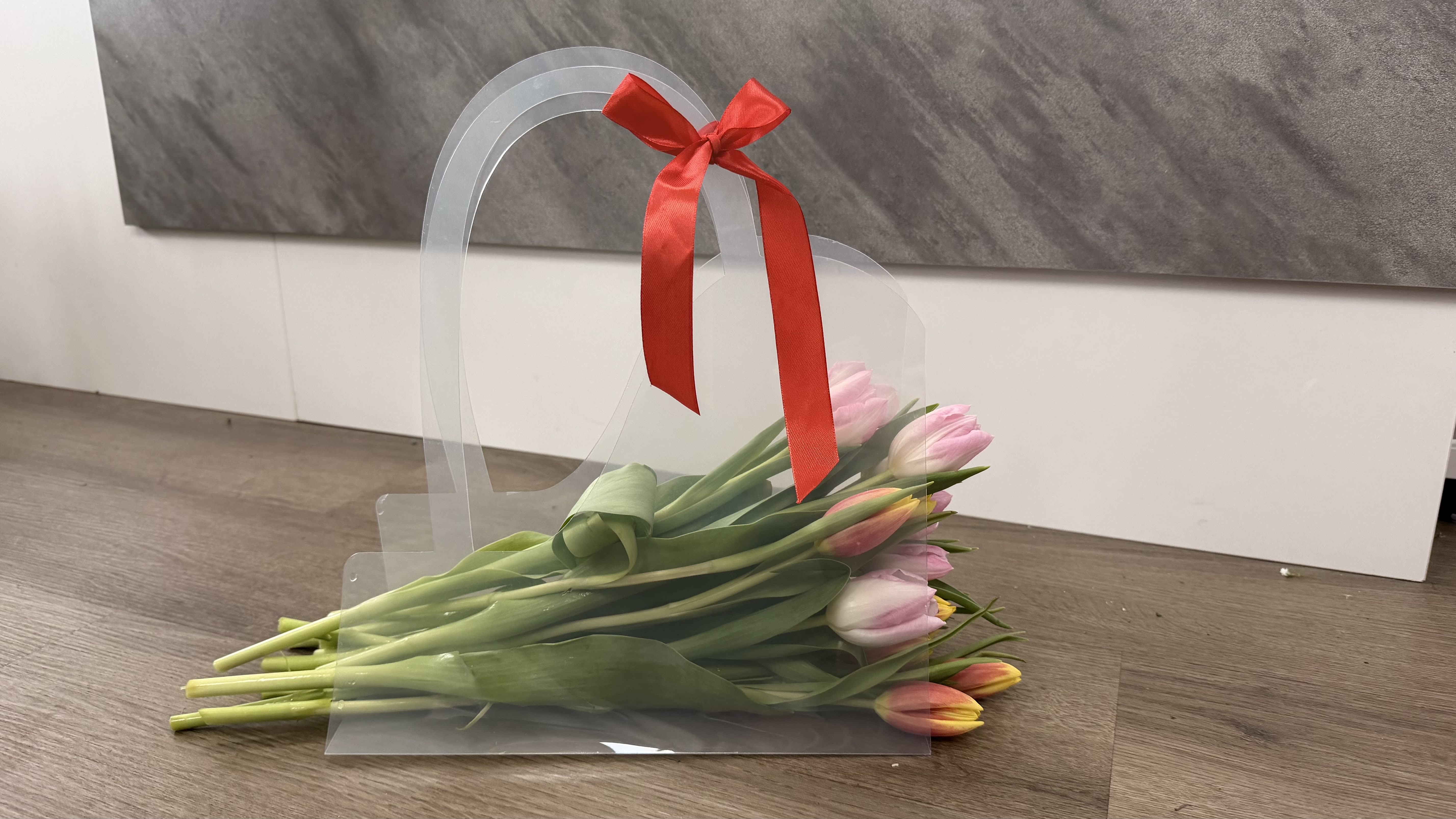 Pink and orange tulips in a clear gift sleeve with a red ribbon