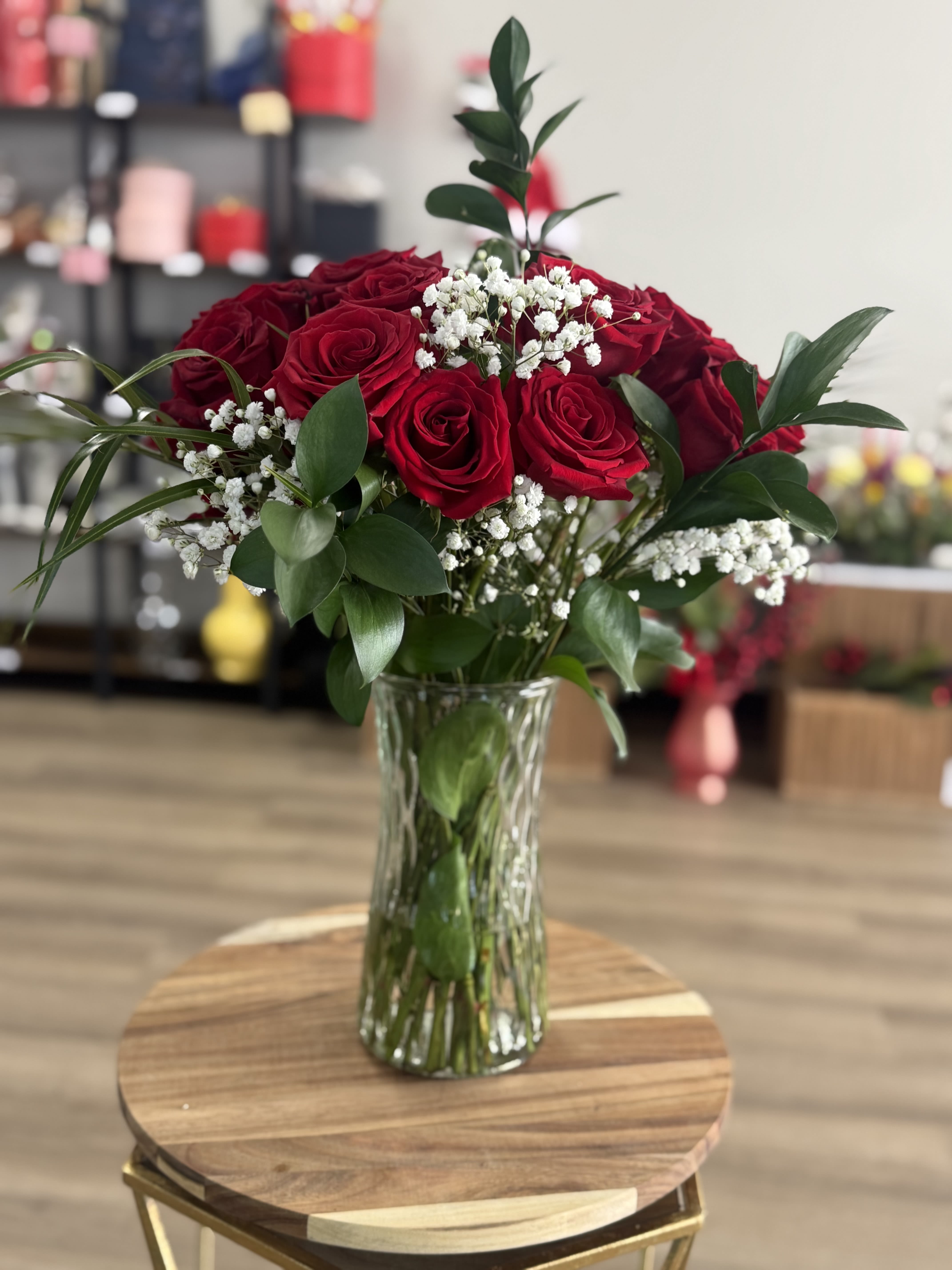 Red roses in a clear glass vase with white baby's breath
