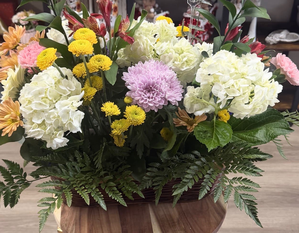 Mixed flower arrangement with white hydrangeas, yellow mums, and a lavender chrysanthemum